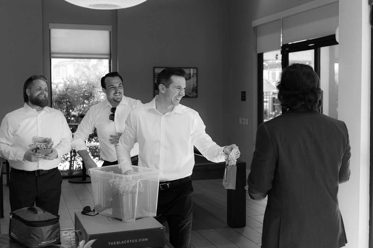 A series of black and white photos showing people interacting in an office or workspace environment.