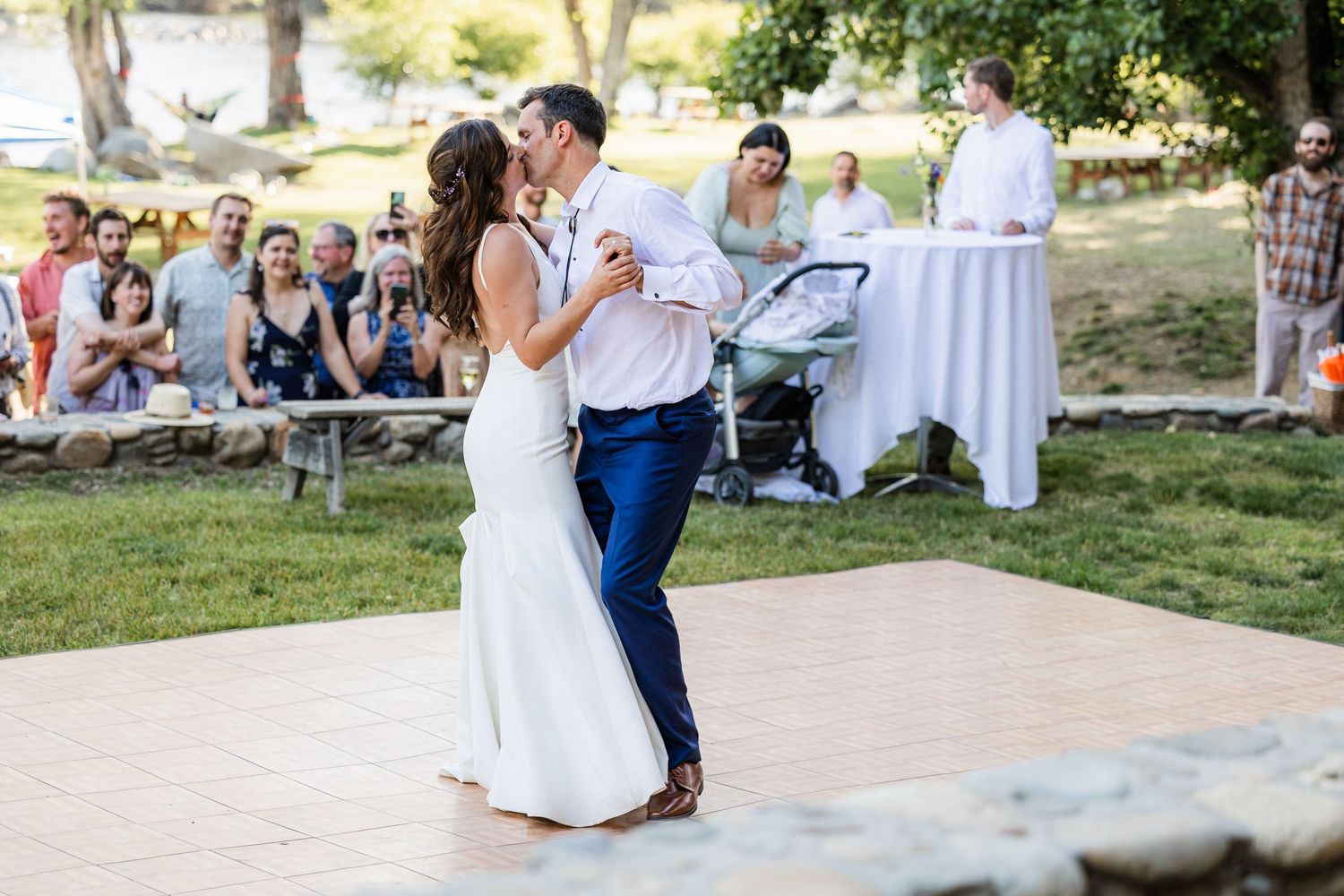 A couple dances together on an outdoor patio during a wedding celebration.