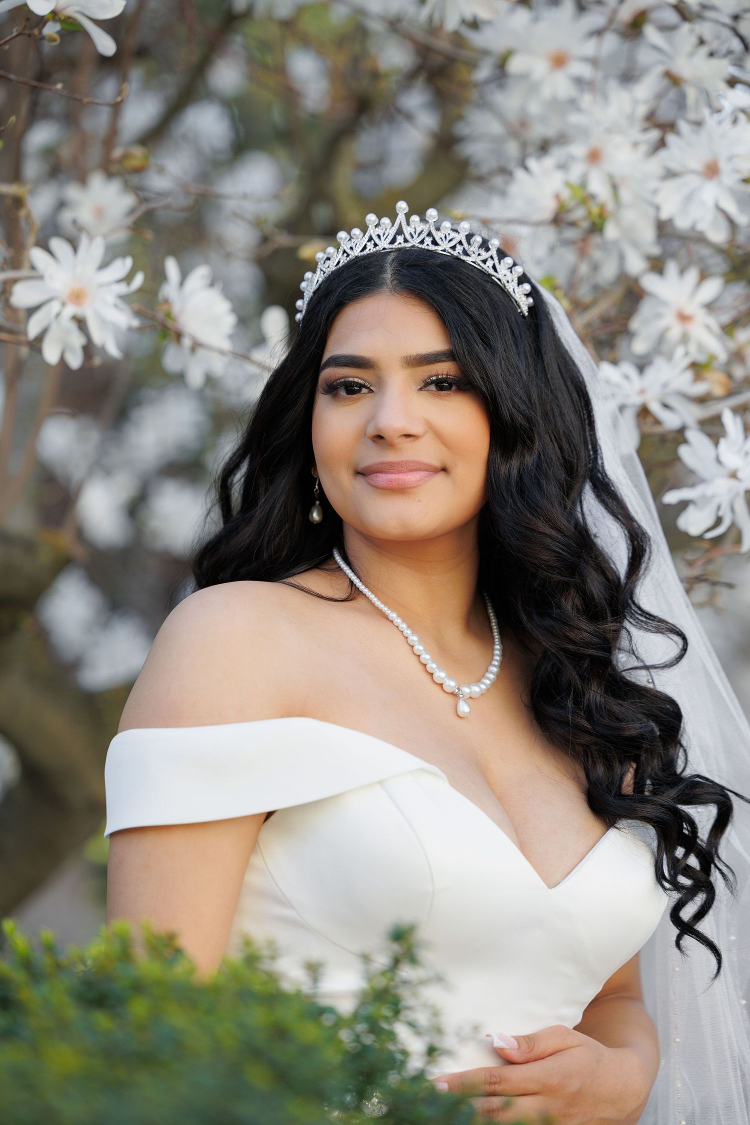 Bridal portrait with white magnolia blossoms, tiara and off-shoulder wedding gown.