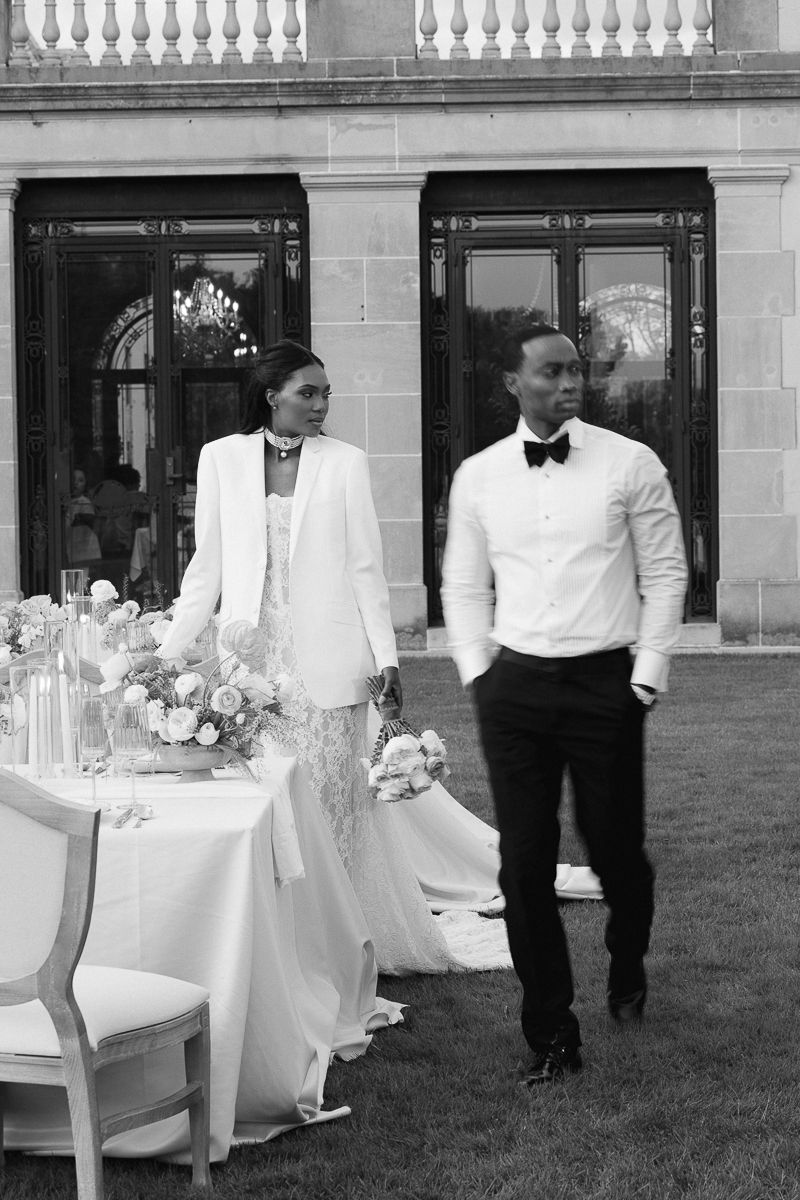 A black and white photo shows wedding tables set up on a grand estate lawn.