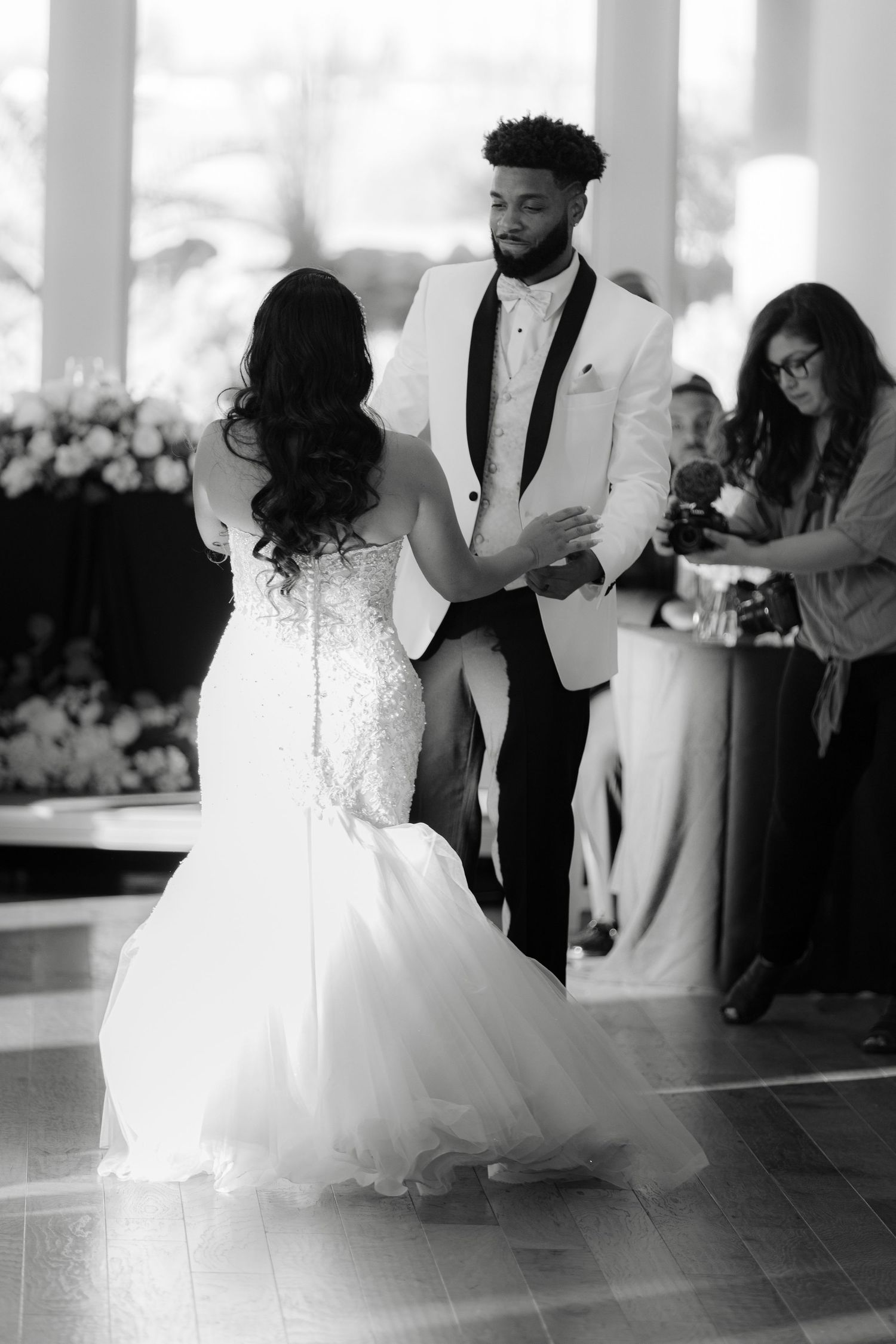 A couple shares an intimate dance together at their wedding reception on a dark dance floor.
