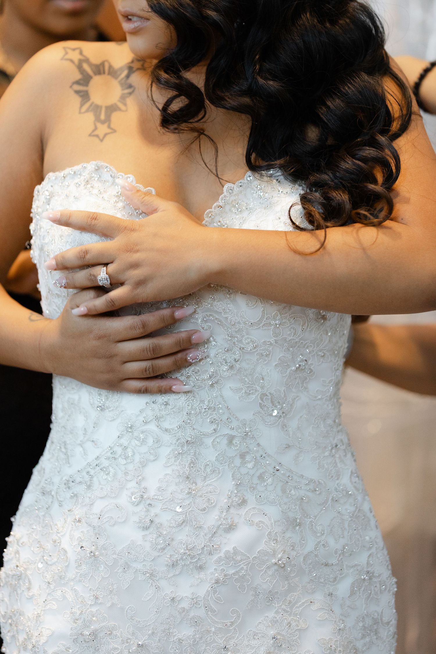 Close-up detail of a white lace wedding dress bodice with delicate beading and embellishments.