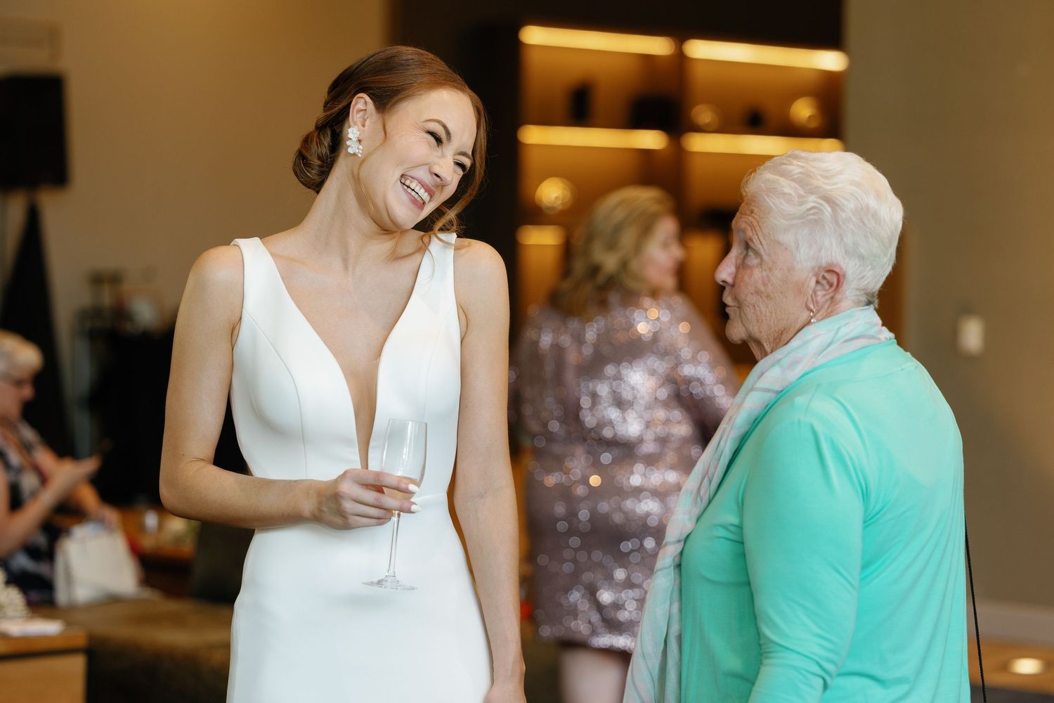 A series of candid wedding reception moments showing guests interacting and sharing drinks in an indoor venue.
