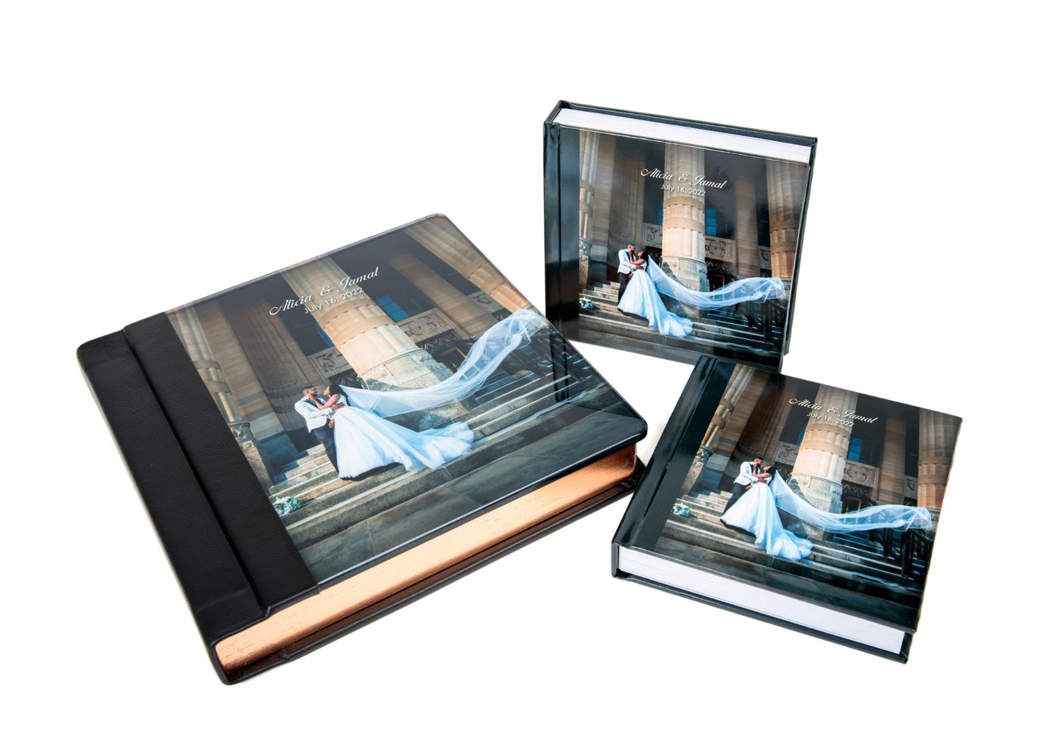Three wedding photo albums of varying sizes featuring a bride and groom cover image, displayed together elegantly.