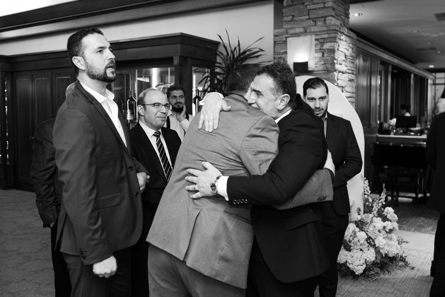 A black and white photo collage showing candid moments from a formal wedding celebration.