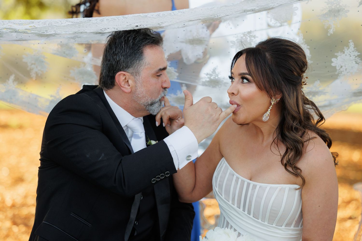 Newlywed couple shares intimate moments during golden hour wedding photo session at sunset.
