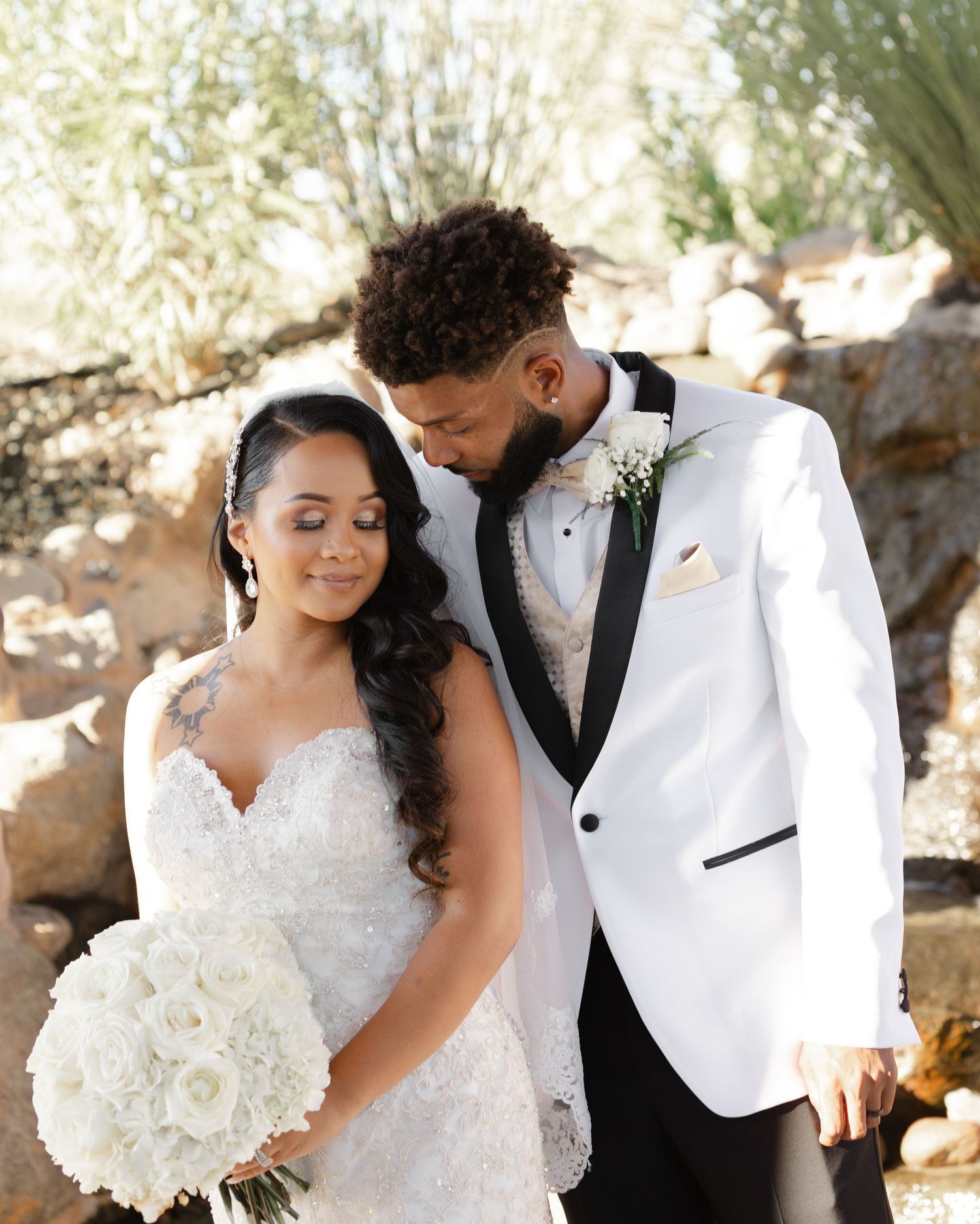 Romantic wedding couple shares tender moments in a series of elegant outdoor portraits with white floral bouquet.