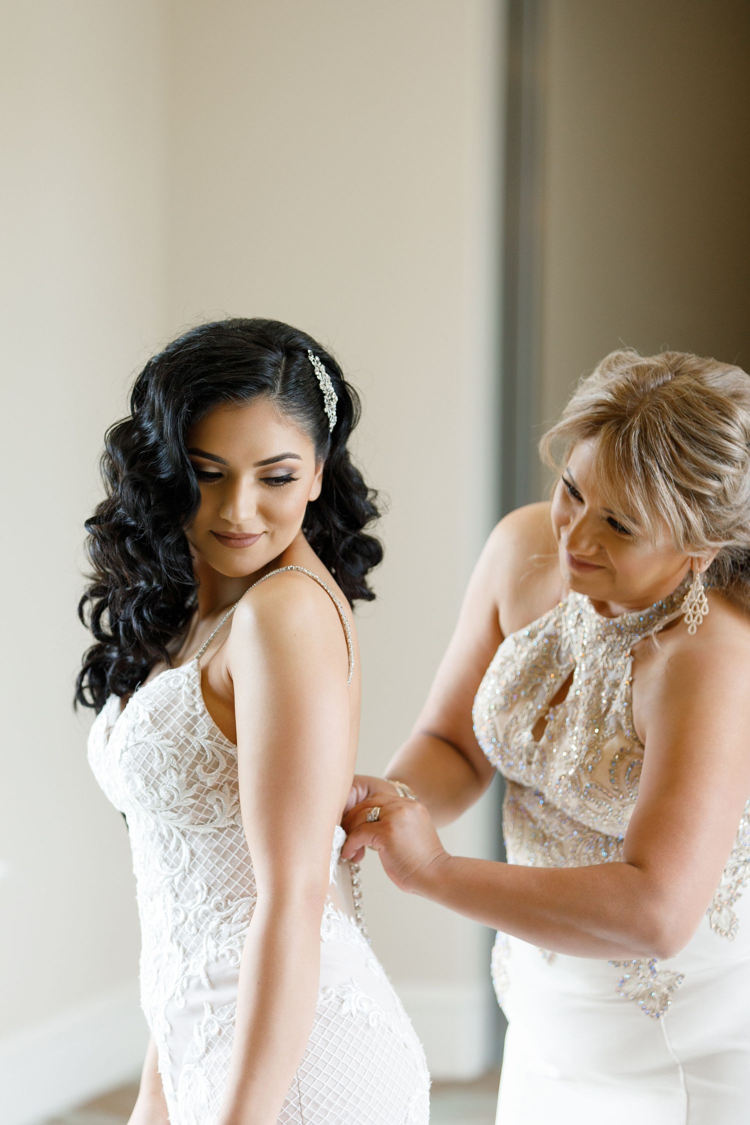 A series of photos showing the back details of a white lace wedding dress being fastened.