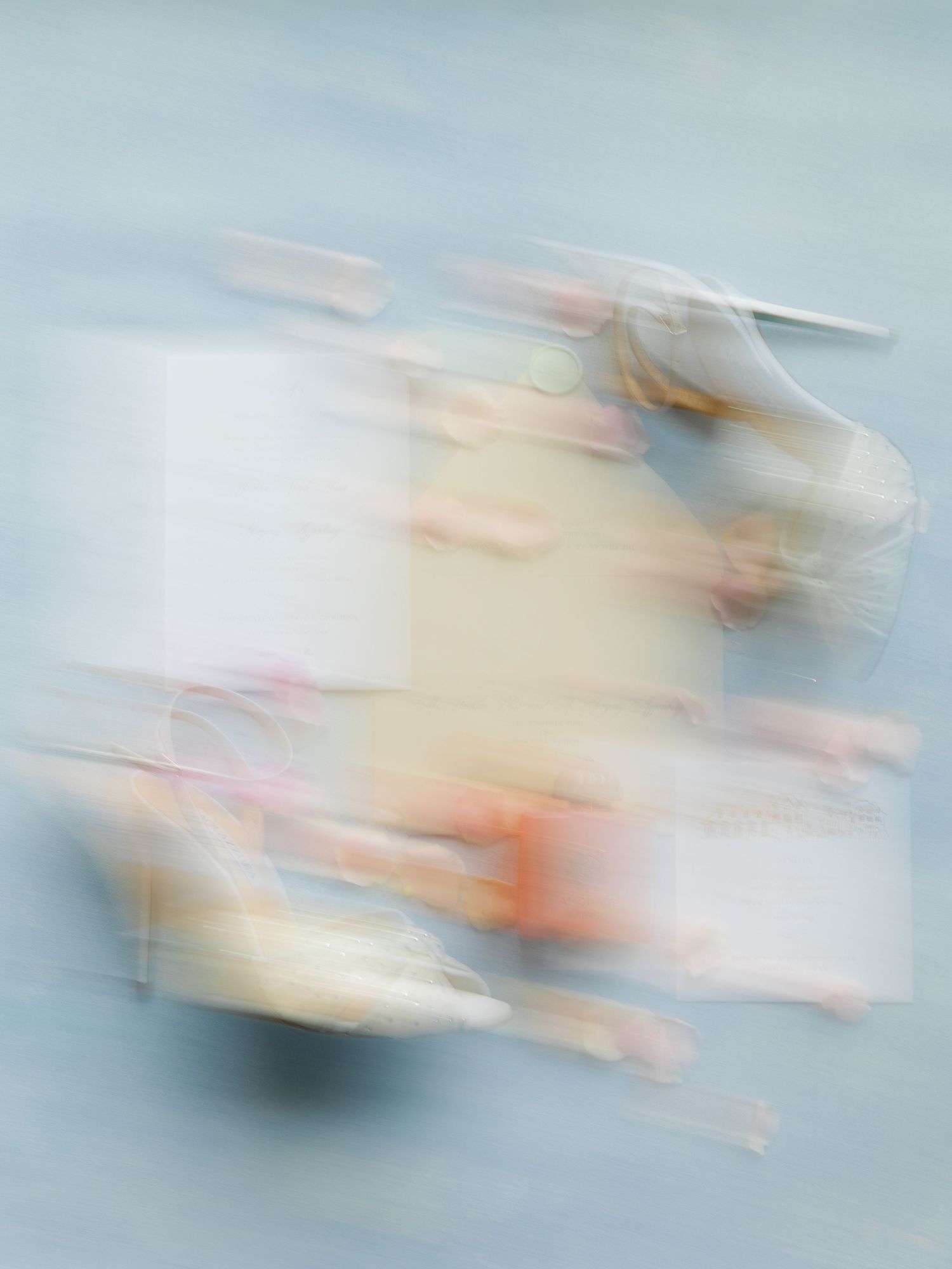 Abstract blurred motion art in soft blue and white tones creates an ethereal flowing effect across the composition.