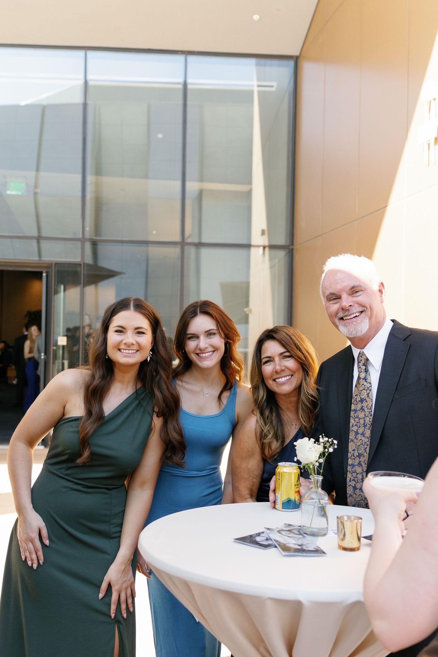 A group of people gather around a cocktail table at an elegant indoor event space.