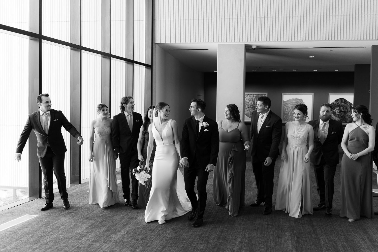 A black and white wedding party photo sequence showing groups of people walking and posing in formal attire.