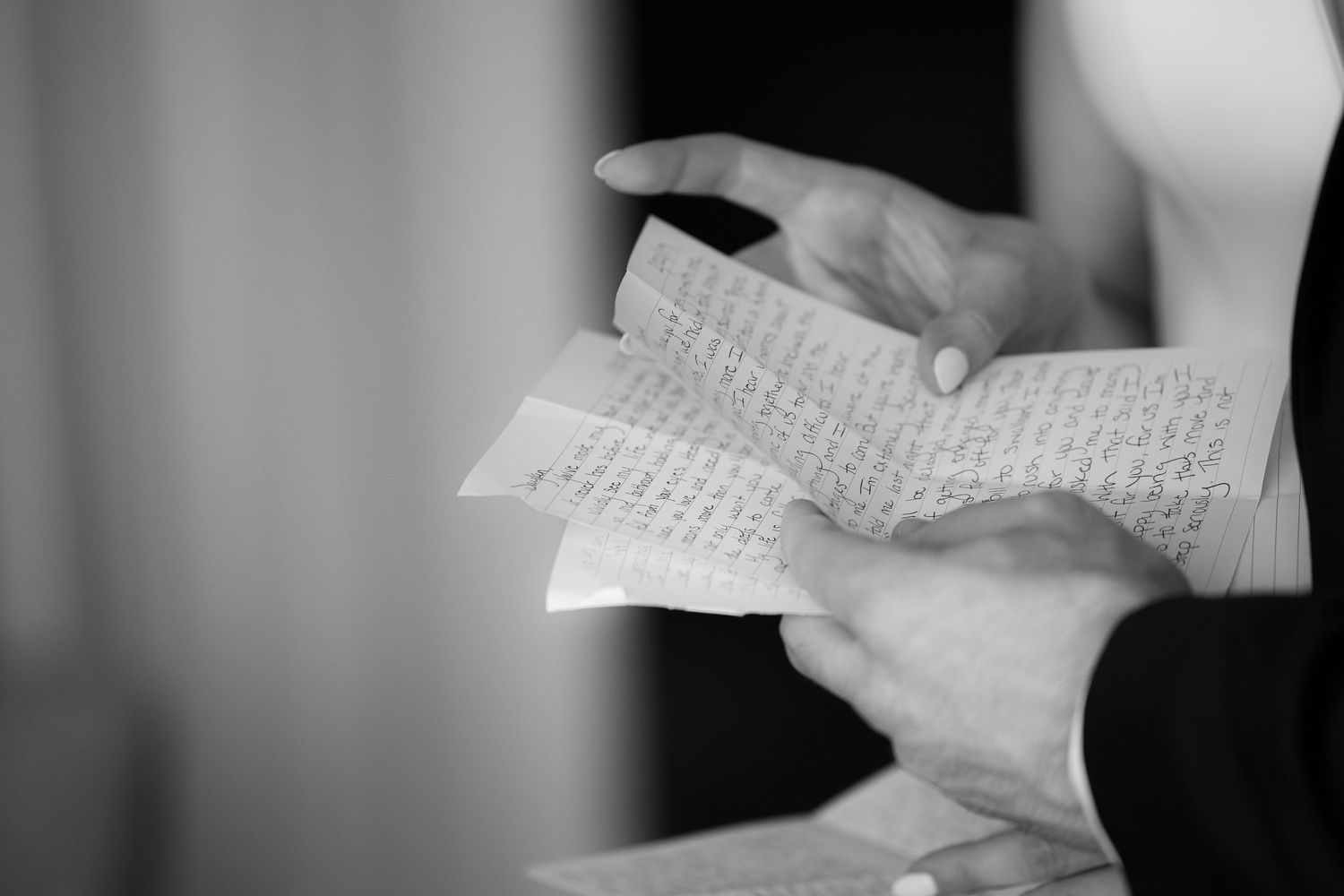 A series of hands holding and reading handwritten letters in black and white.