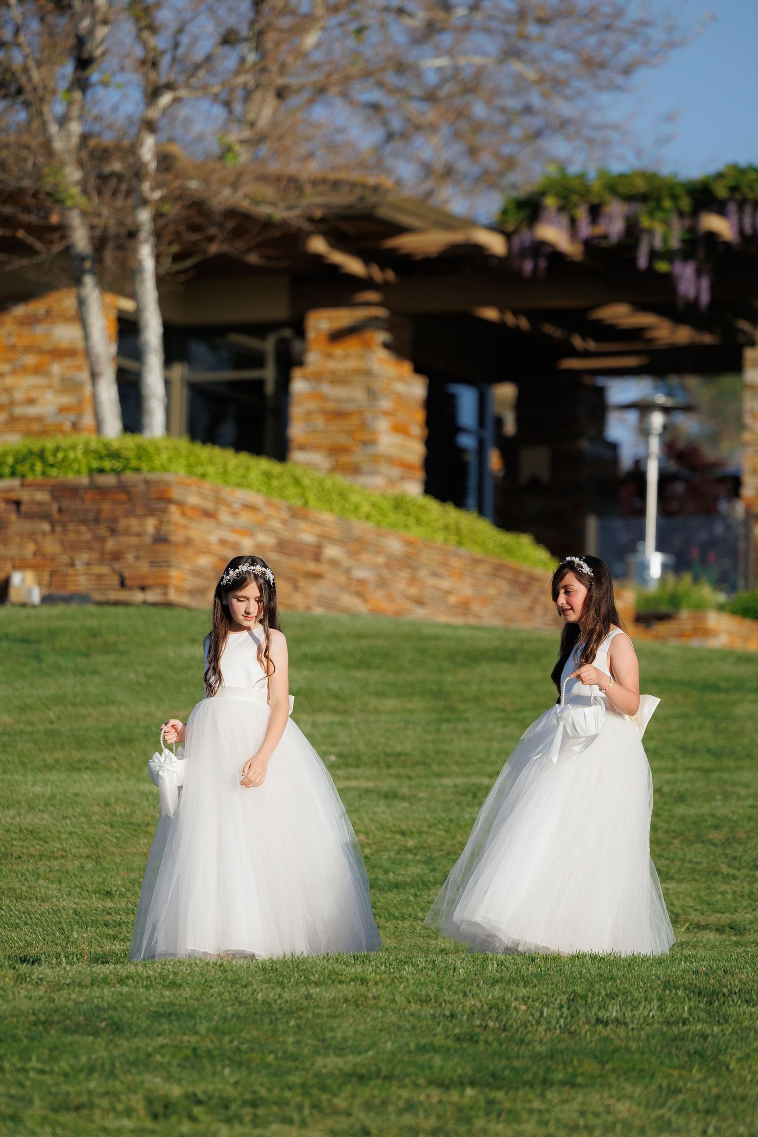 A series of white wedding dresses photographed in sequence across a green grassy lawn on a sunny day.