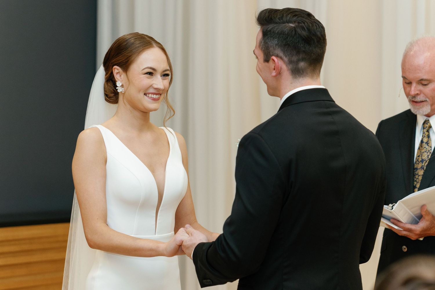 A bride and groom share a joyful moment during their first dance at their wedding reception.