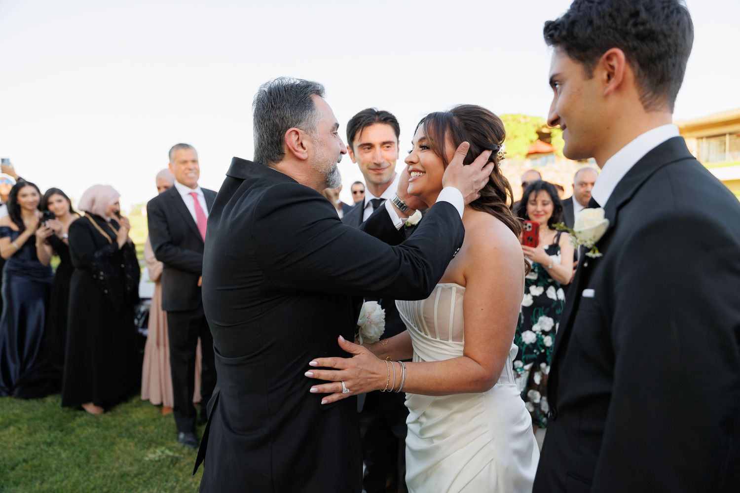Wedding guests dance and celebrate together at an outdoor evening reception.