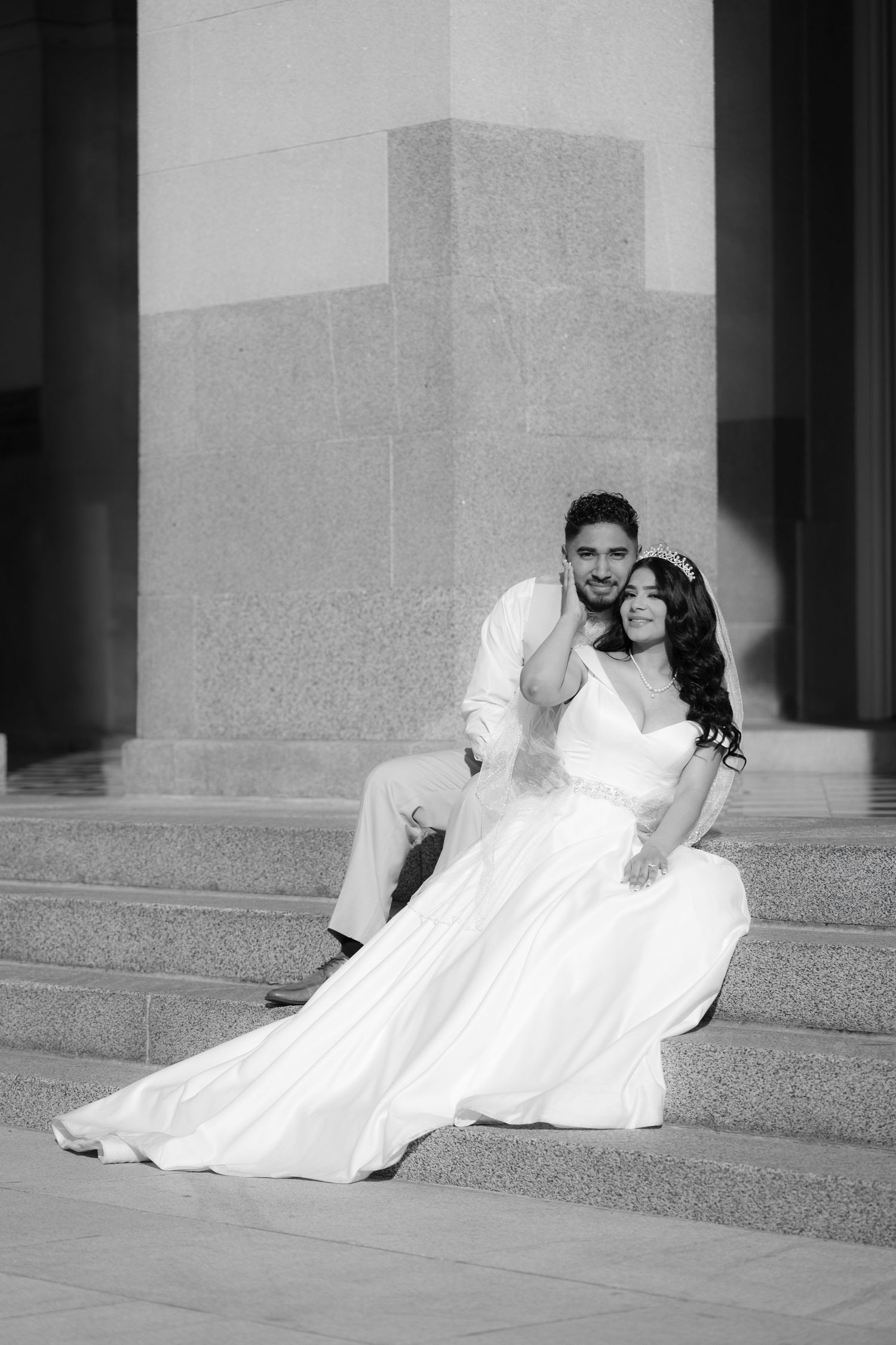 Black and white artistic wedding portraits on stone steps with dramatic lighting.