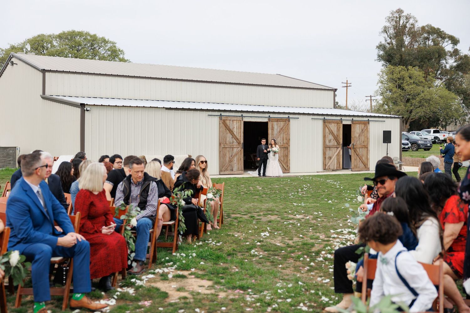 A large group of people stand in line outside a building waiting to enter an event.