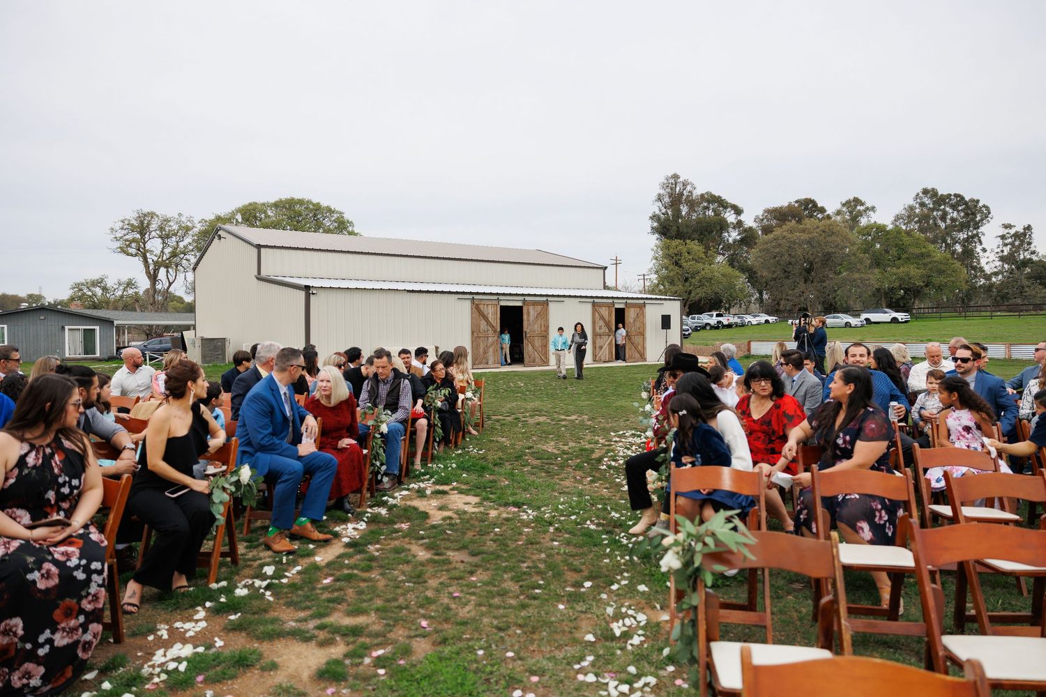 Outdoor wedding ceremony setup with wooden benches arranged in rows facing a simple altar structure.