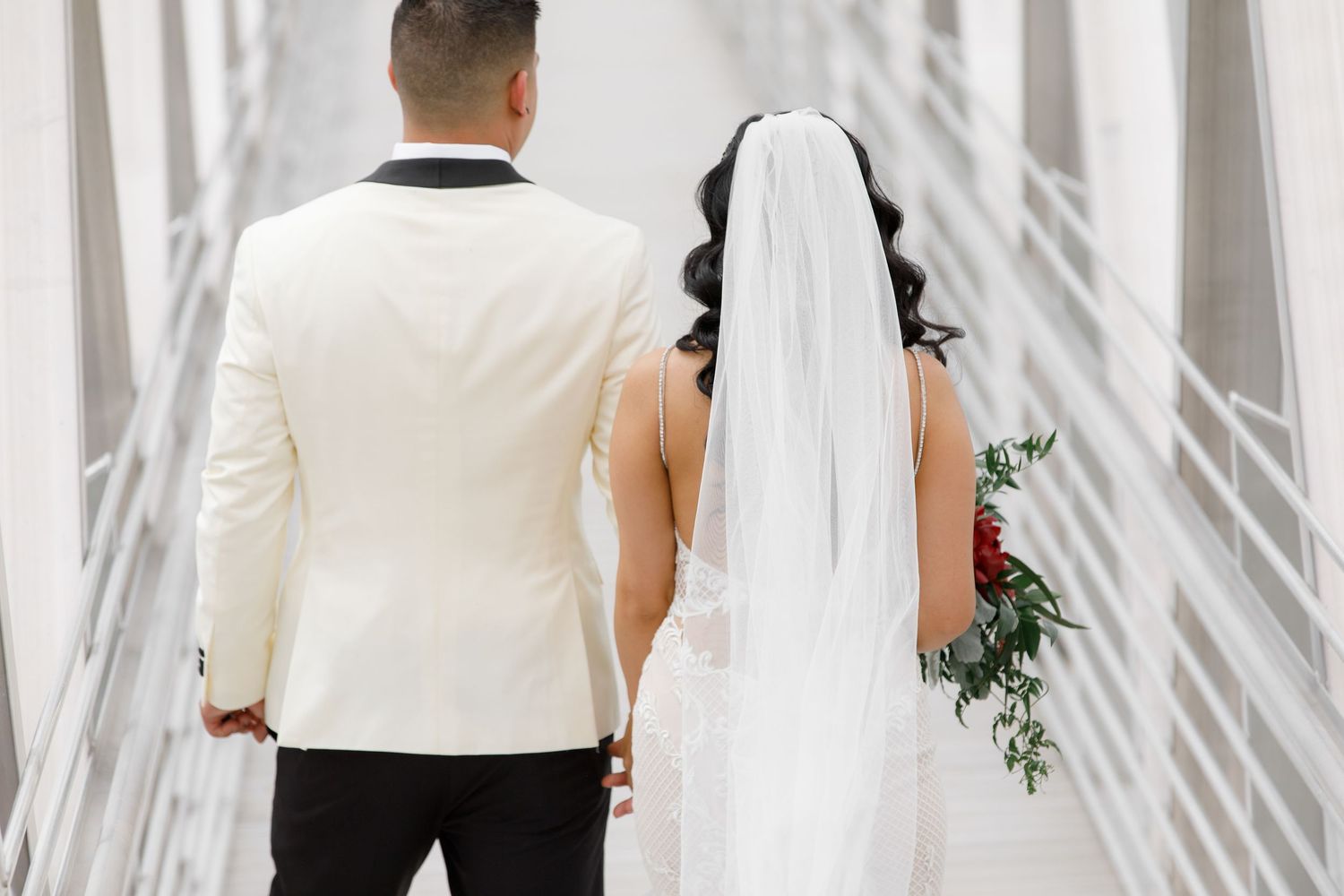 A bride and groom stand together under a white fabric canopy during an elegant wedding ceremony.