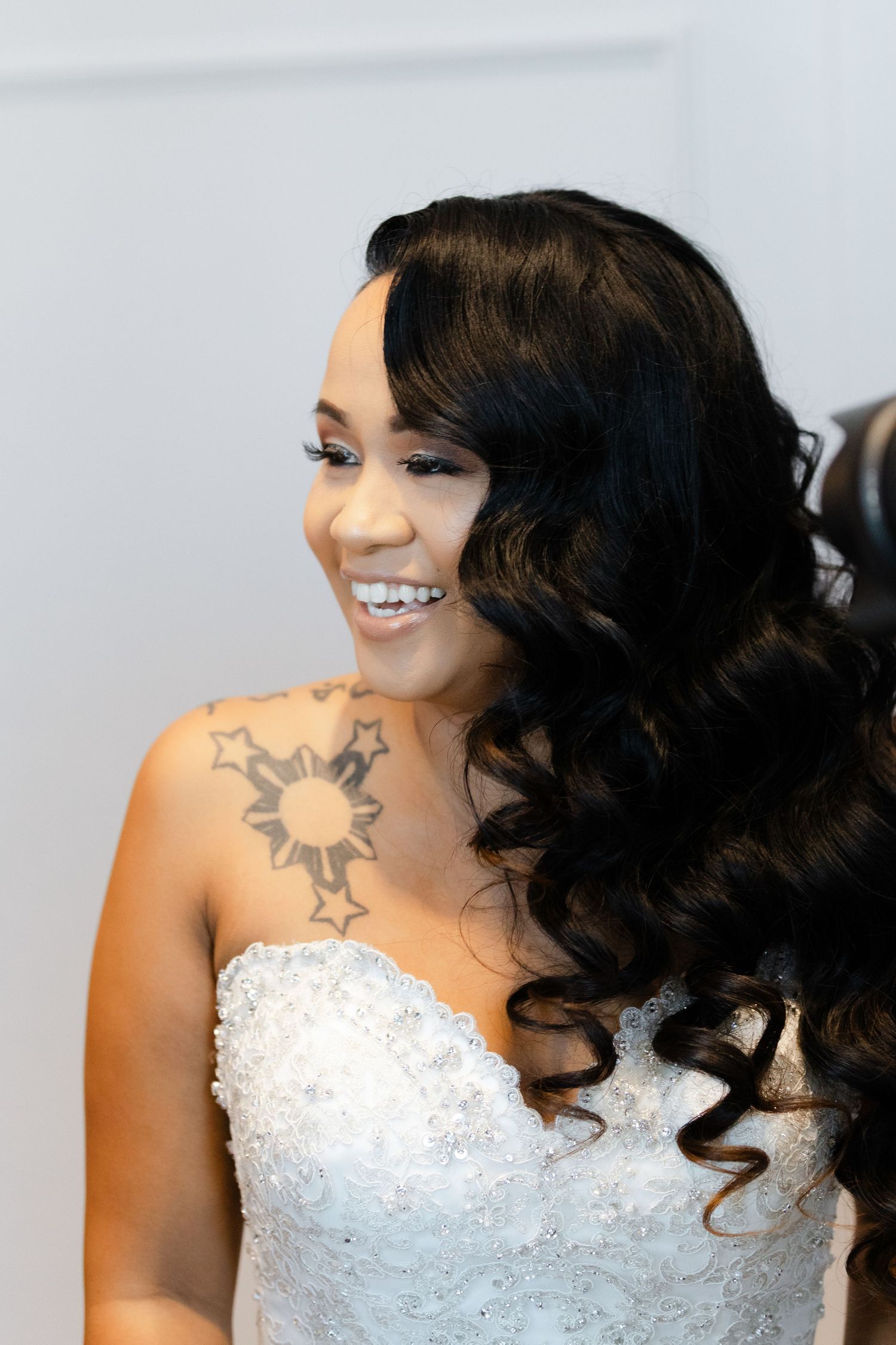 Close-up shots of a bride in a white beaded wedding dress with dark curled hair and a shoulder tattoo.