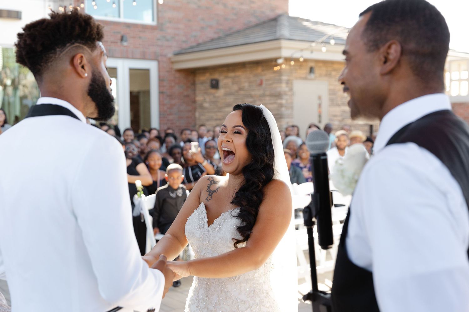 A joyful wedding celebration with guests and bridal party members sharing candid moments in a brick venue.