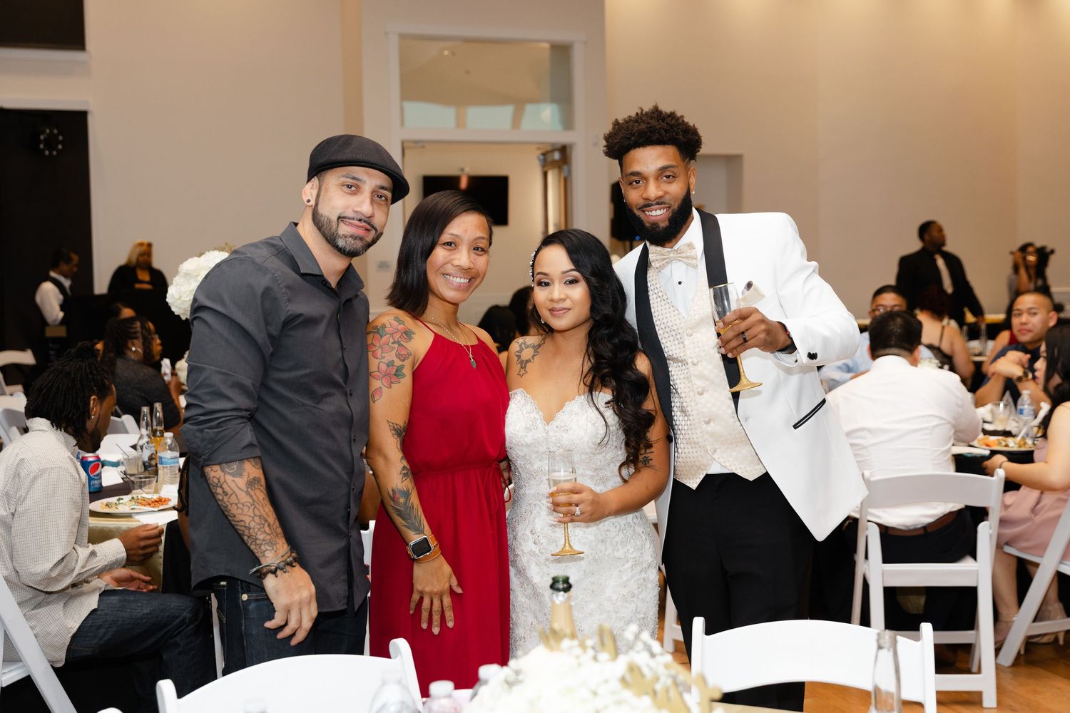 People gathered around tables at a formal event in a bright white room with modern decor.