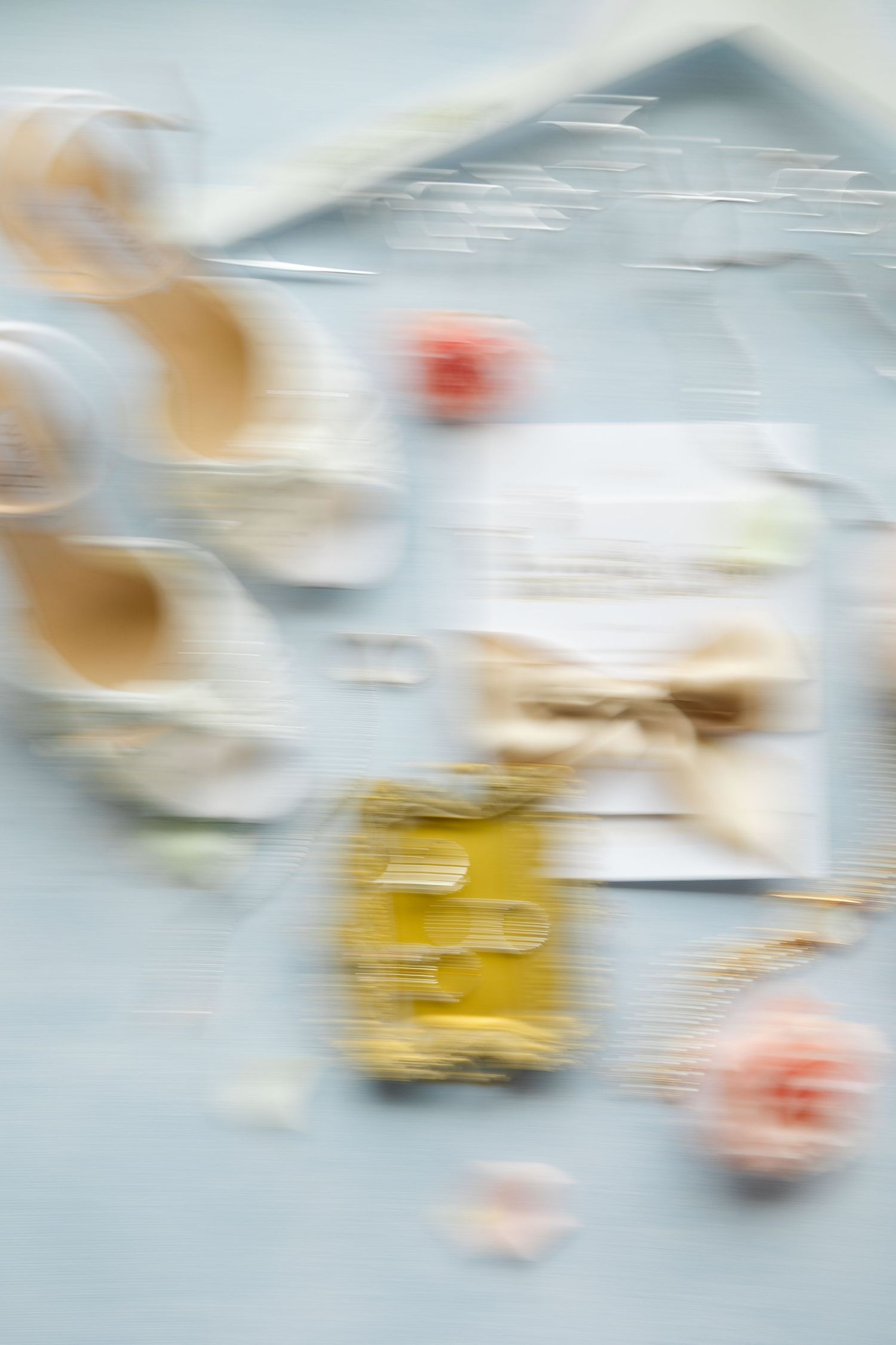 Abstract blurred motion background with soft gray and yellow tones creating an ethereal flowing effect.