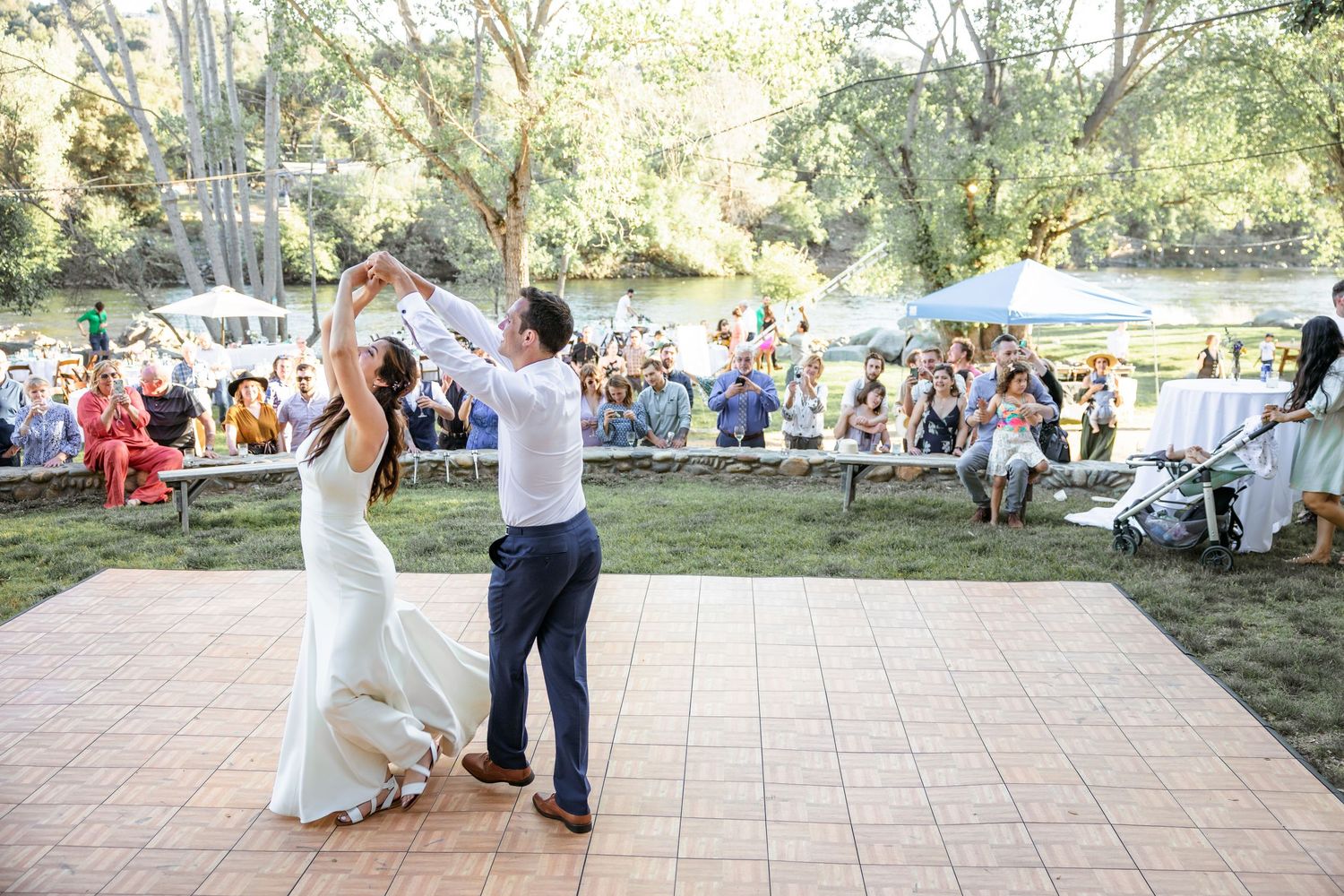 Couples dance together on an outdoor patio during a summer wedding reception celebration.