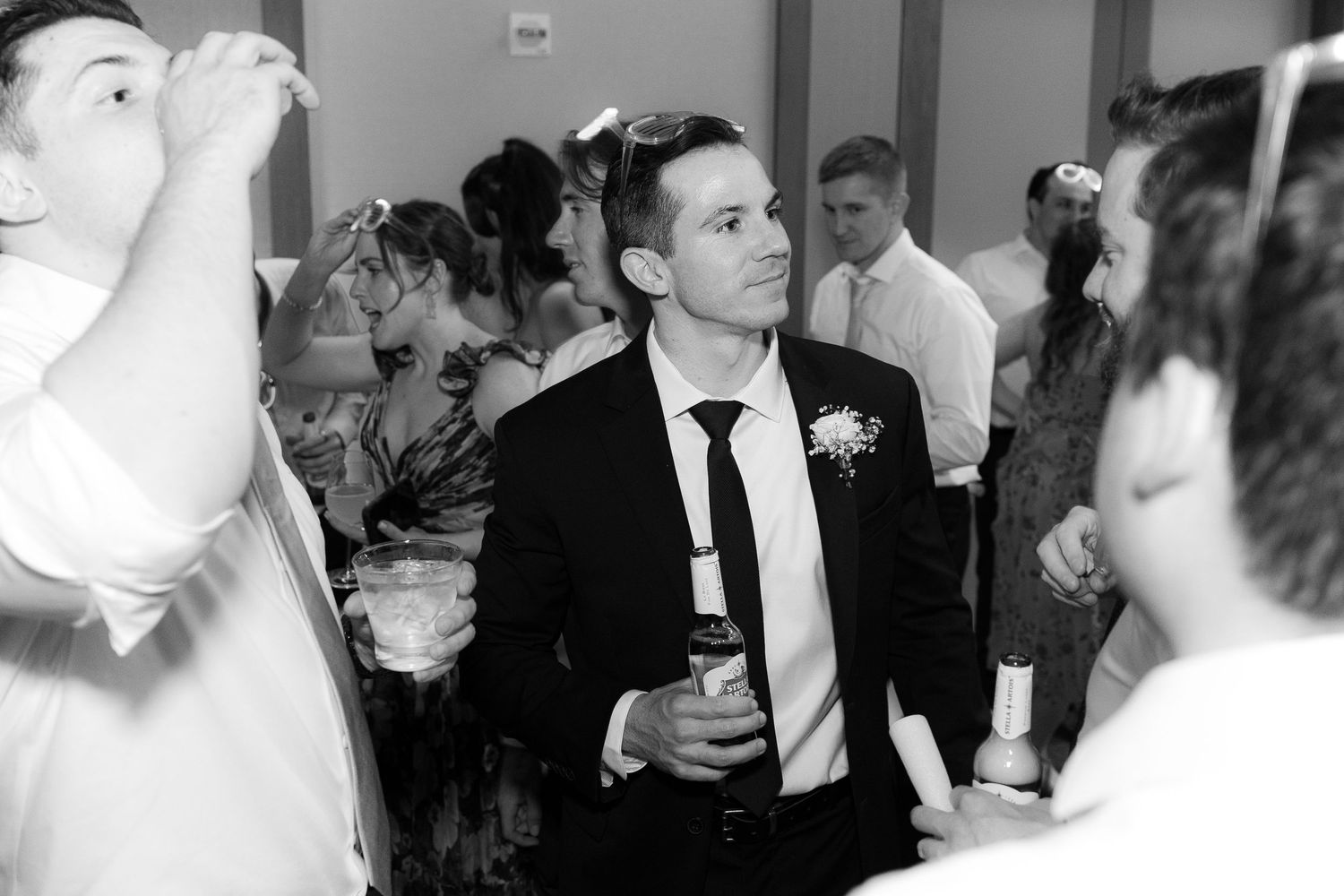A black and white photo montage showing wedding celebration moments with dancing and socializing at a reception.