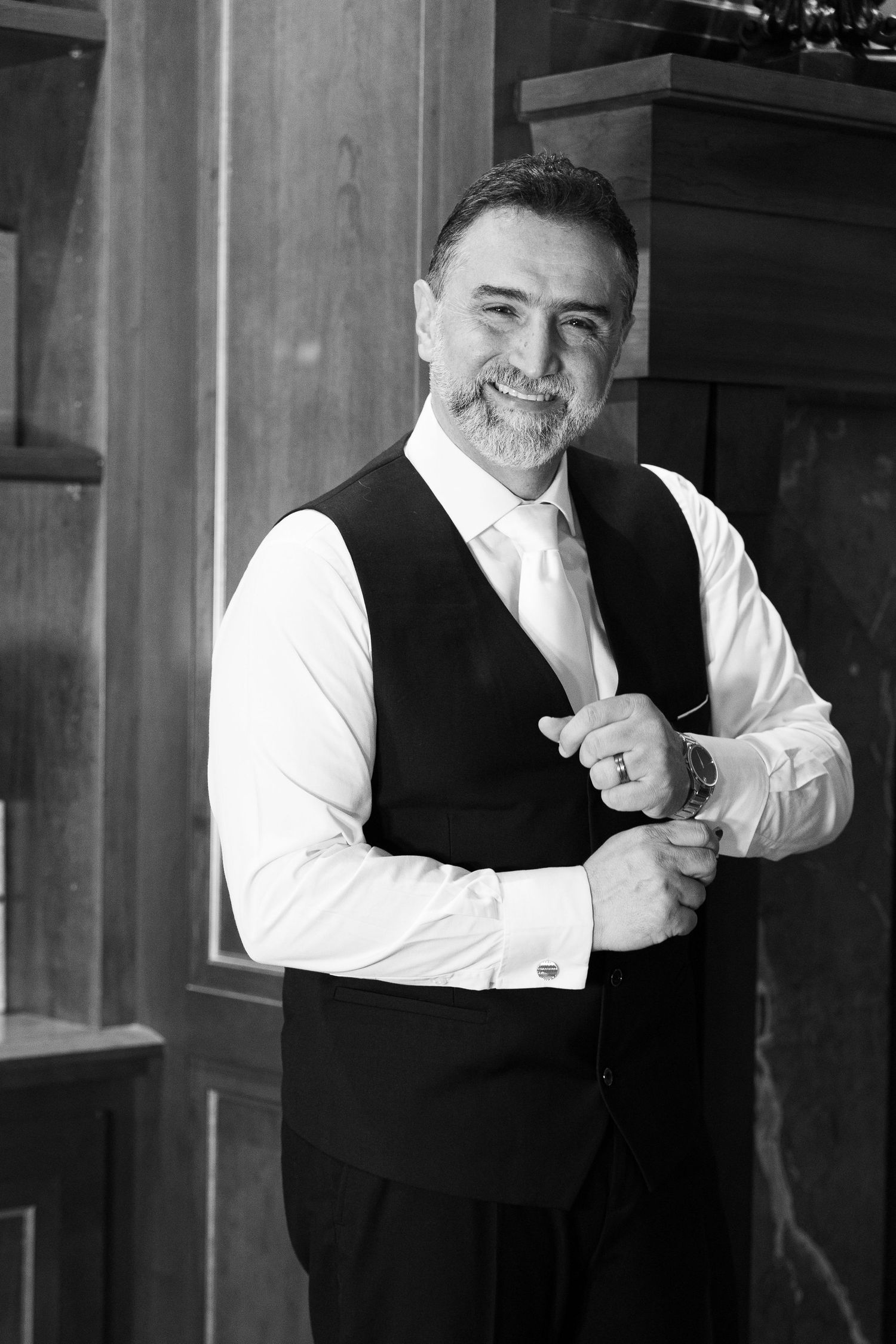 A sequence of black and white portraits showing a person in a vest and white shirt making expressive gestures.