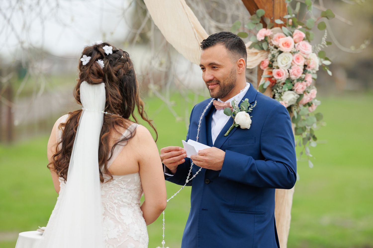 A couple shares a romantic moment outdoors during their wedding celebration.
