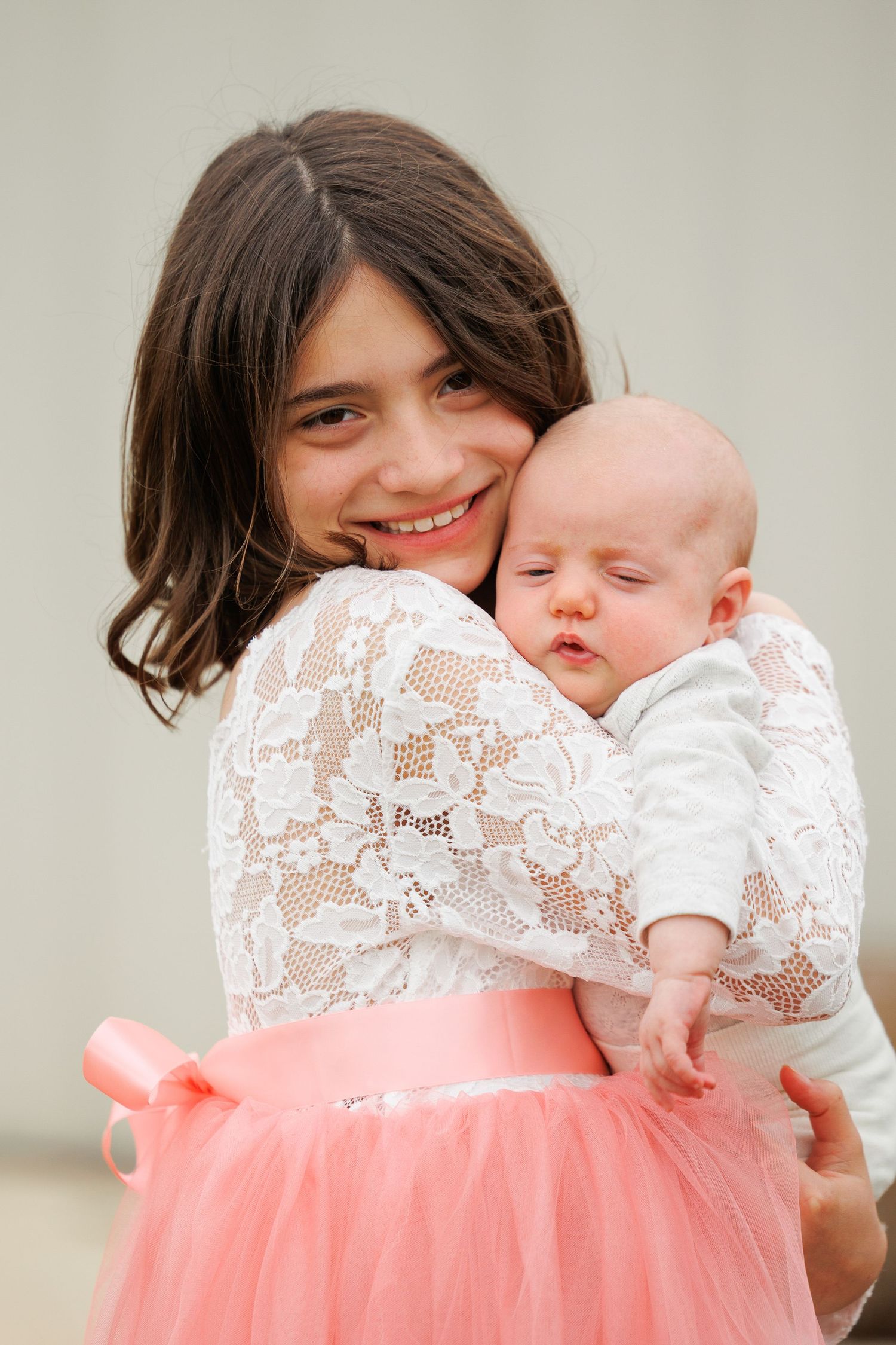A tender moment captured in a series of photos showing a parent cradling a sleeping newborn baby against a white background.