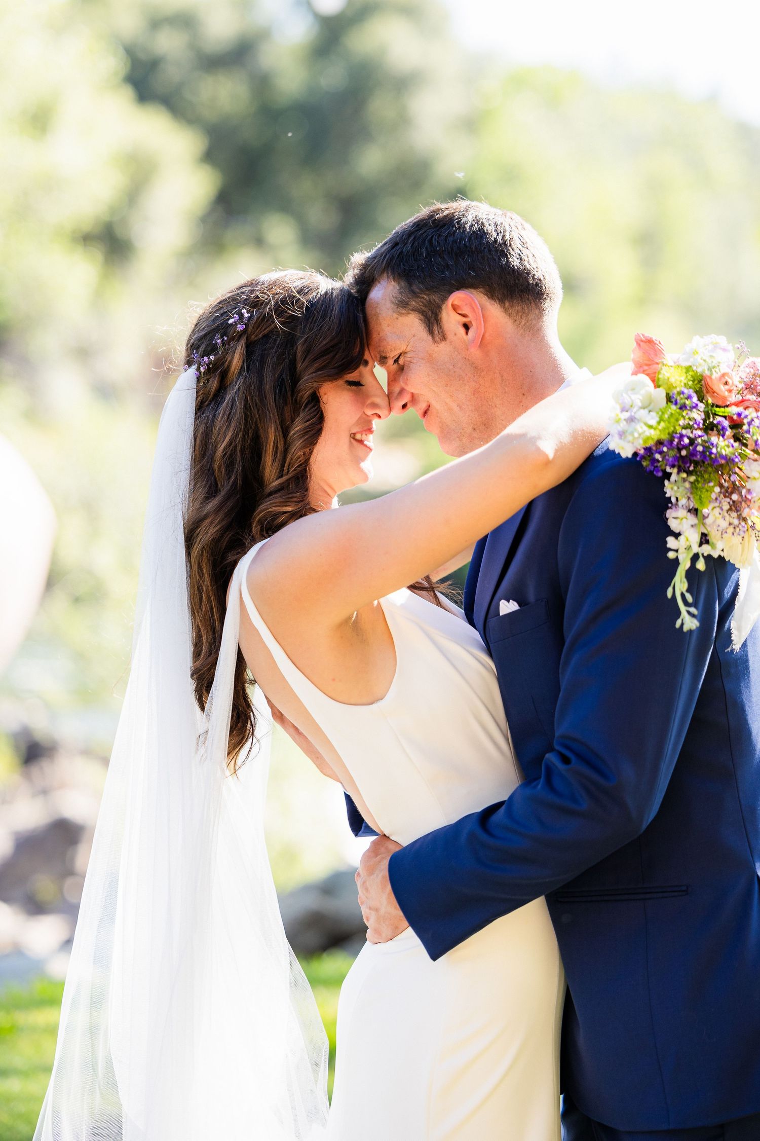 Romantic wedding photo sequence showing four tender moments between newlyweds in navy suit and white dress kissing outdoors.