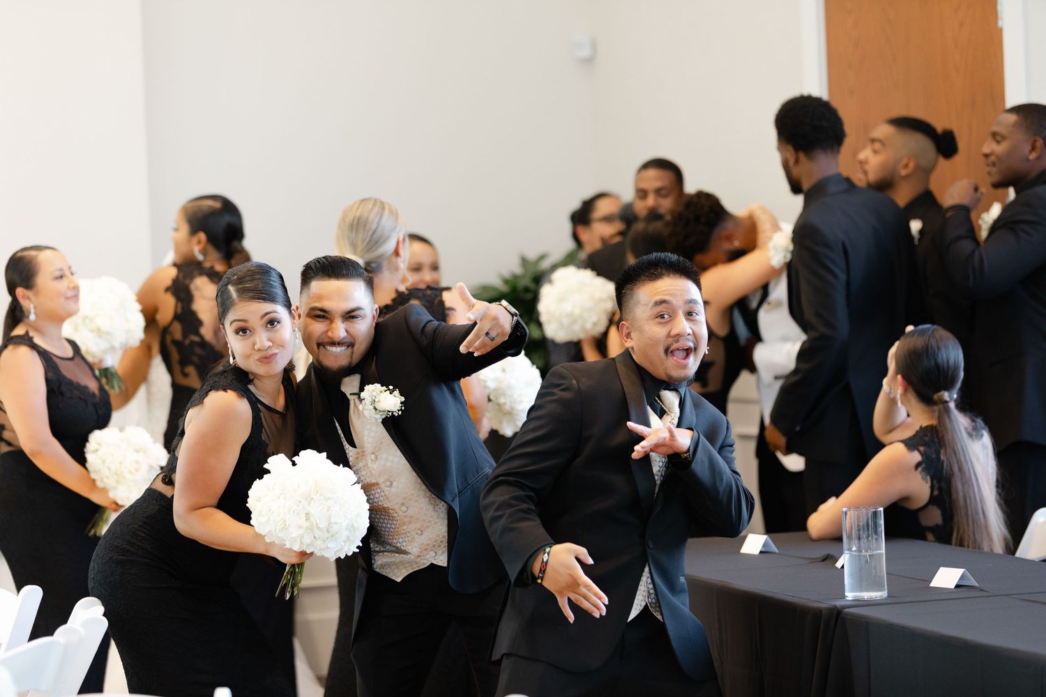 A group of people dancing and celebrating at what appears to be a wedding reception or party.