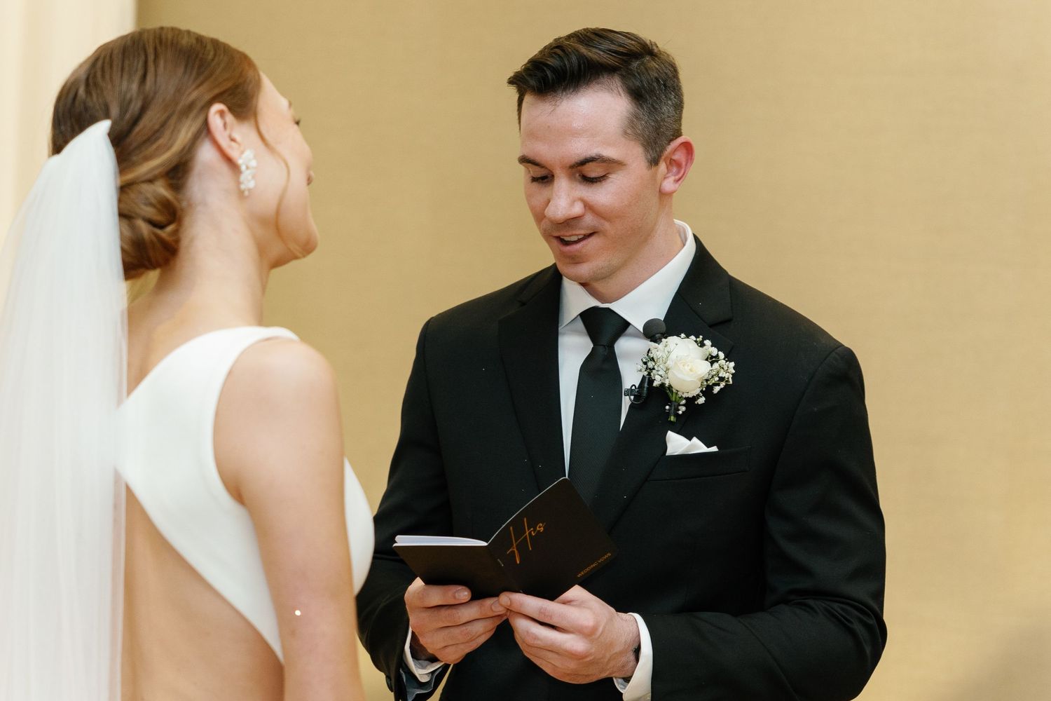A bride and groom exchange vows during an intimate indoor wedding ceremony.