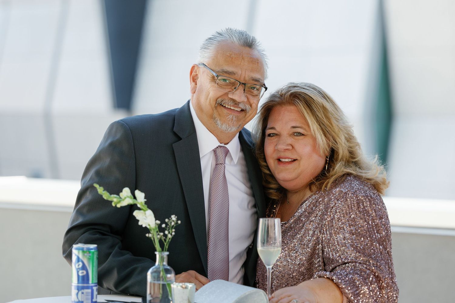 Guests share joyful moments during a wedding reception celebration at a bright indoor venue.