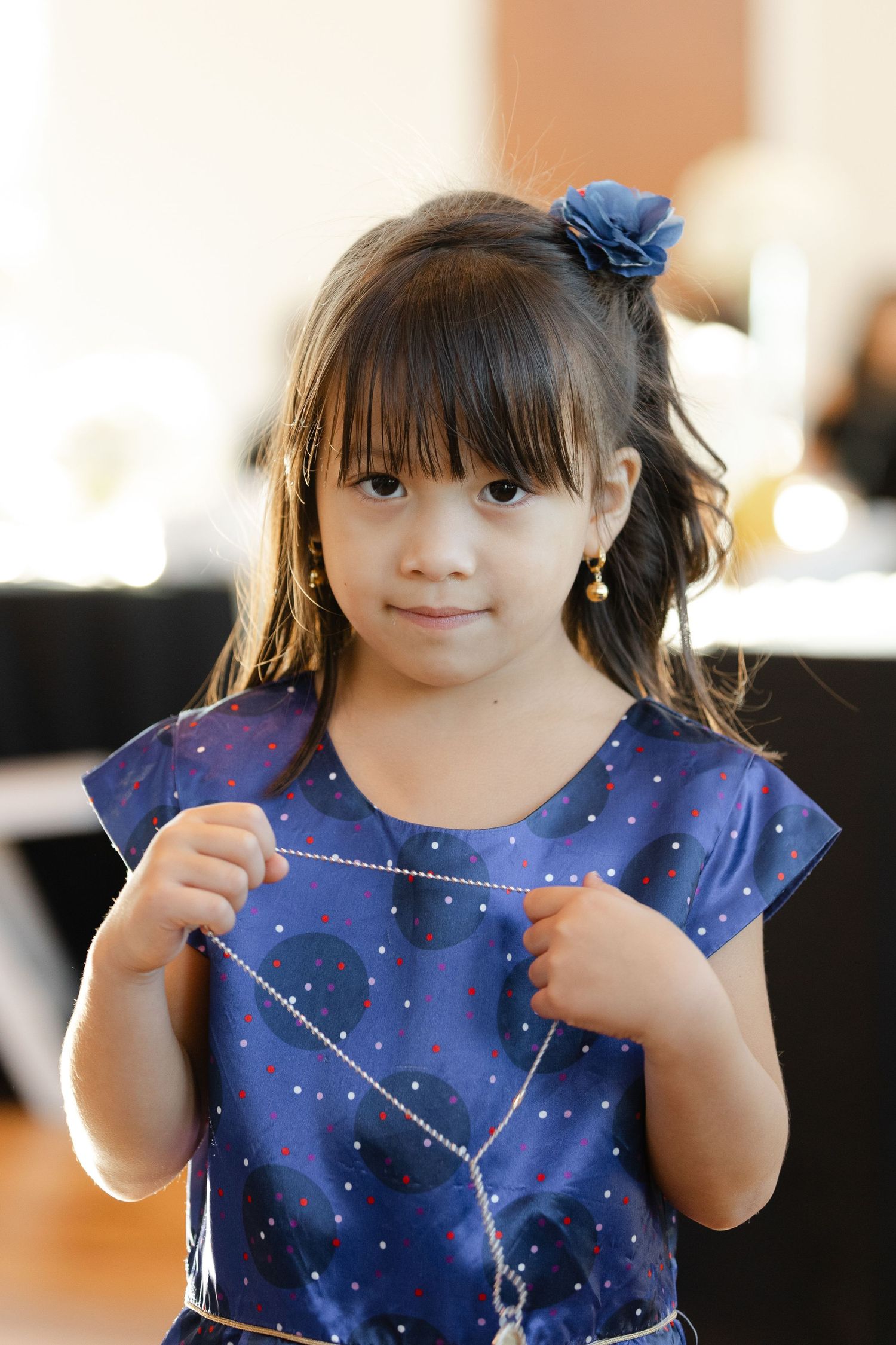 Young child wearing a sparkly blue dress with celestial patterns and a blue hair accessory.