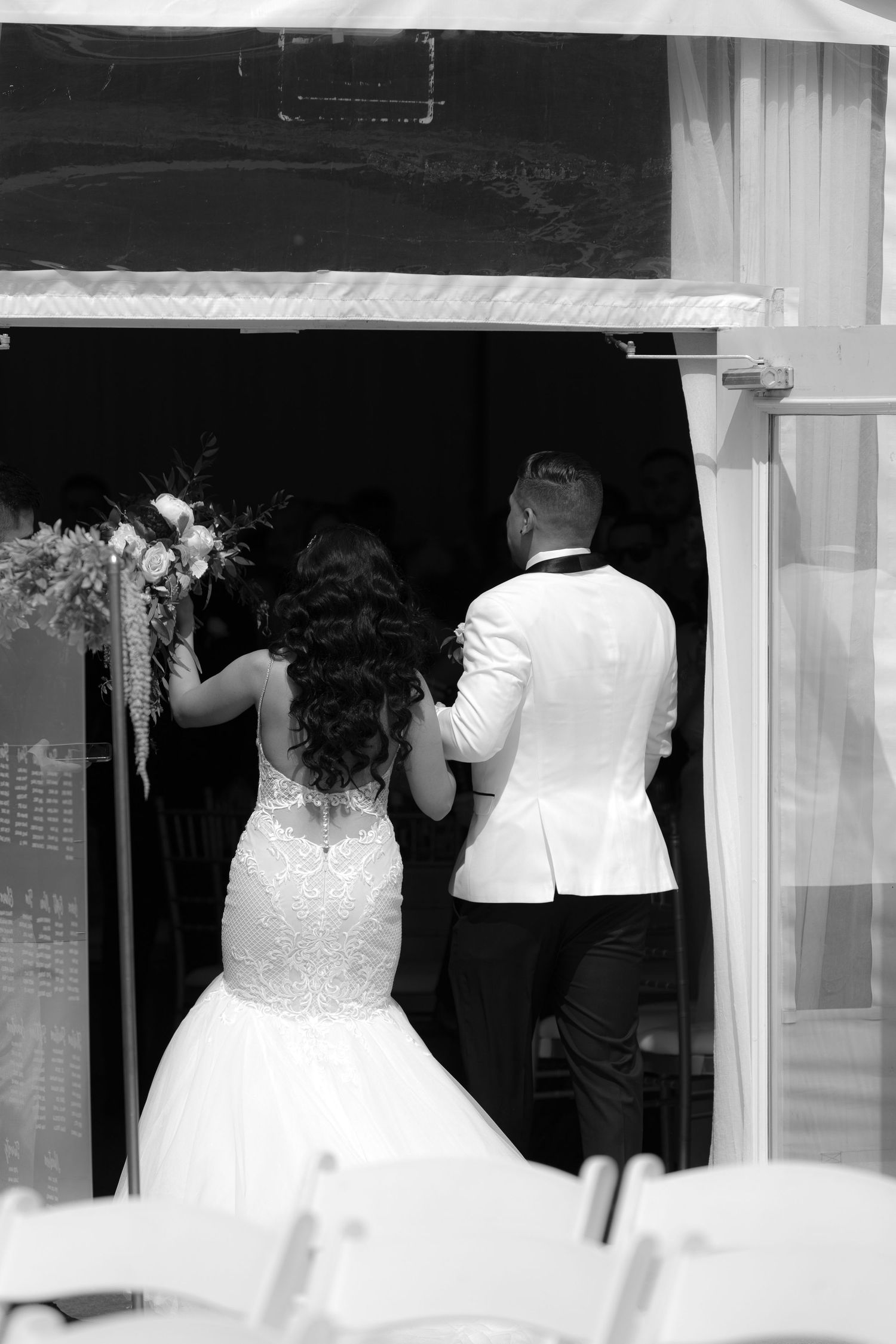 Wedding dress displays in a bridal shop window showcase elegant white gowns with detailed bodices and full skirts.