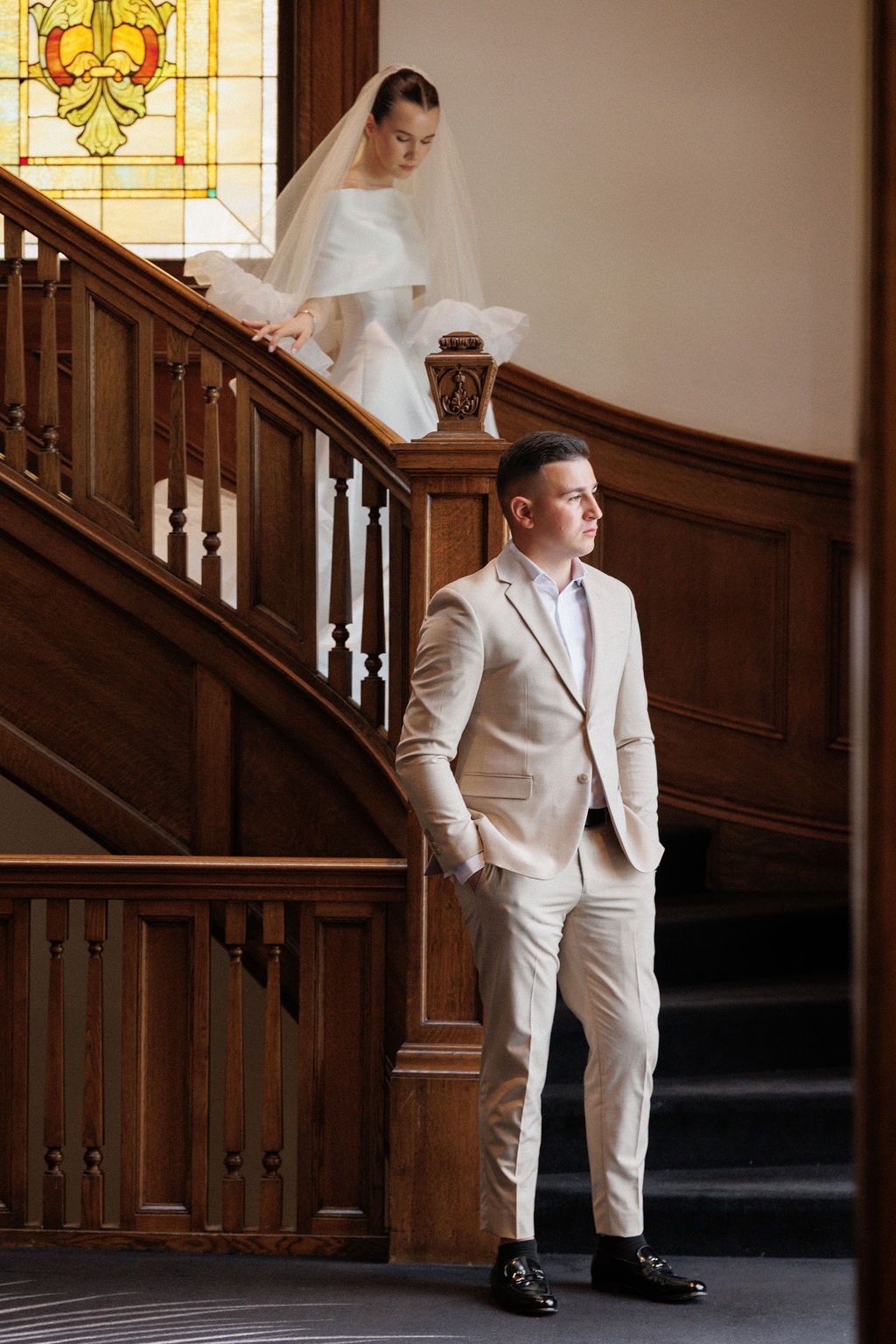 A sequence of wedding photos showing a person in a light suit walking down an elegant wooden staircase.
