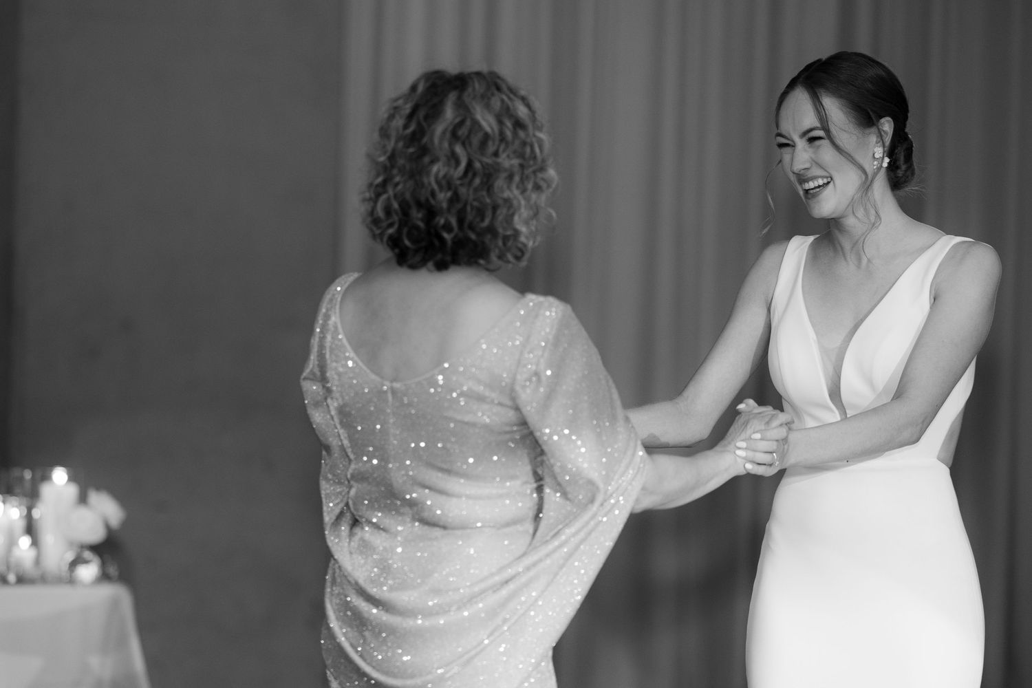 A series of black and white wedding photos showing details of lace dresses and intimate dance moments at a reception.