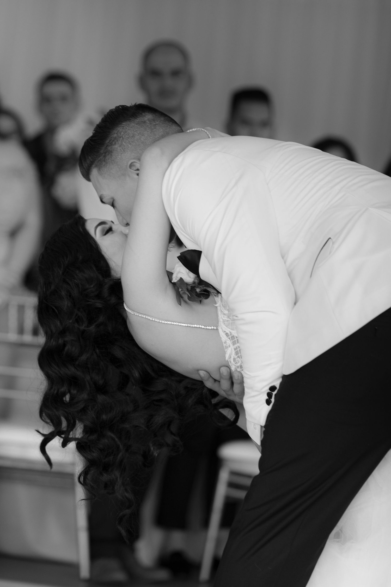 Black and white sequence of a couple sharing a romantic dip during their first dance at a wedding reception.
