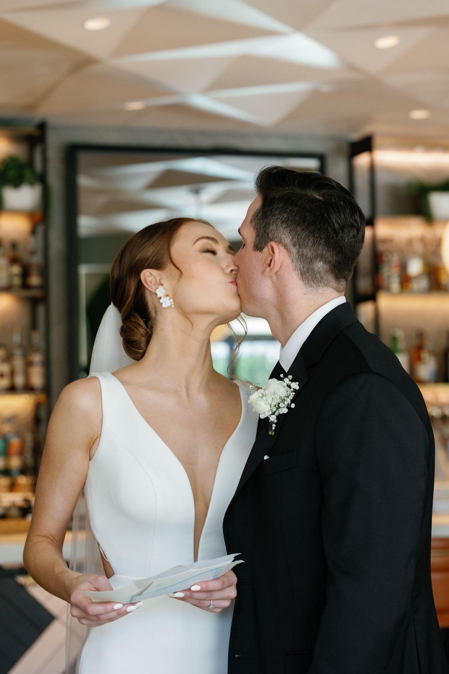 A bride and groom share intimate kisses in a series of romantic wedding photos taken indoors.
