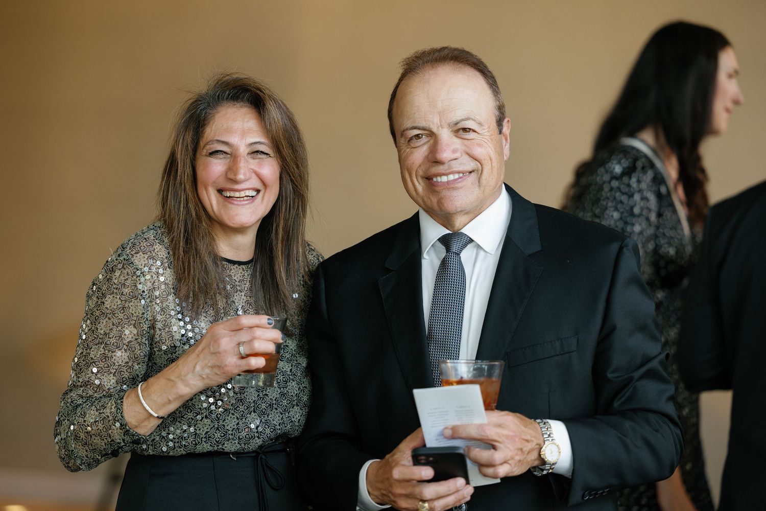 A group of people holding coffee cups and smiling during a casual business gathering.