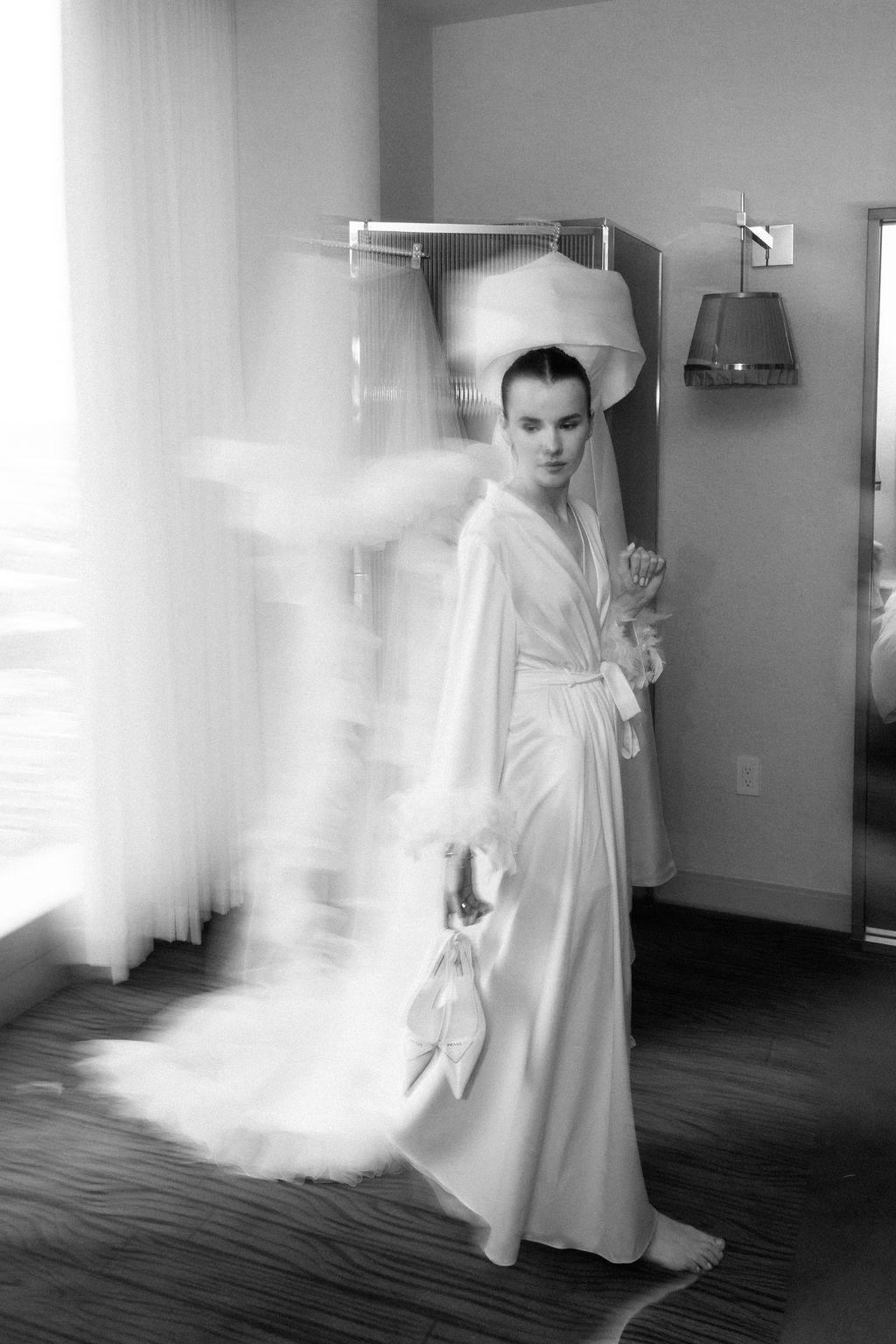 Black and white photo of someone in a white robe with flowing fabric motion effect.