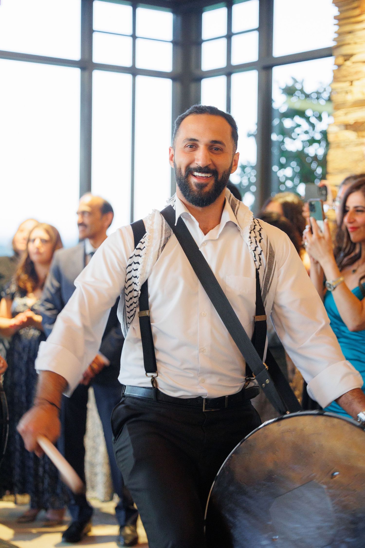 A sequence of photos shows a person in suspenders and white shirt dancing energetically at an indoor celebration.
