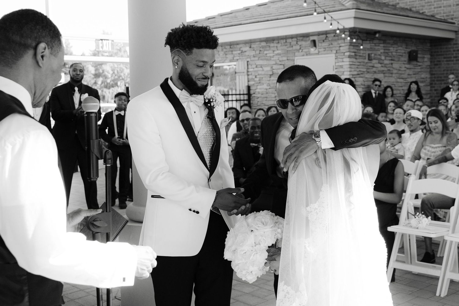 A collection of black and white wedding photos showing candid moments of celebration and dancing at a reception.