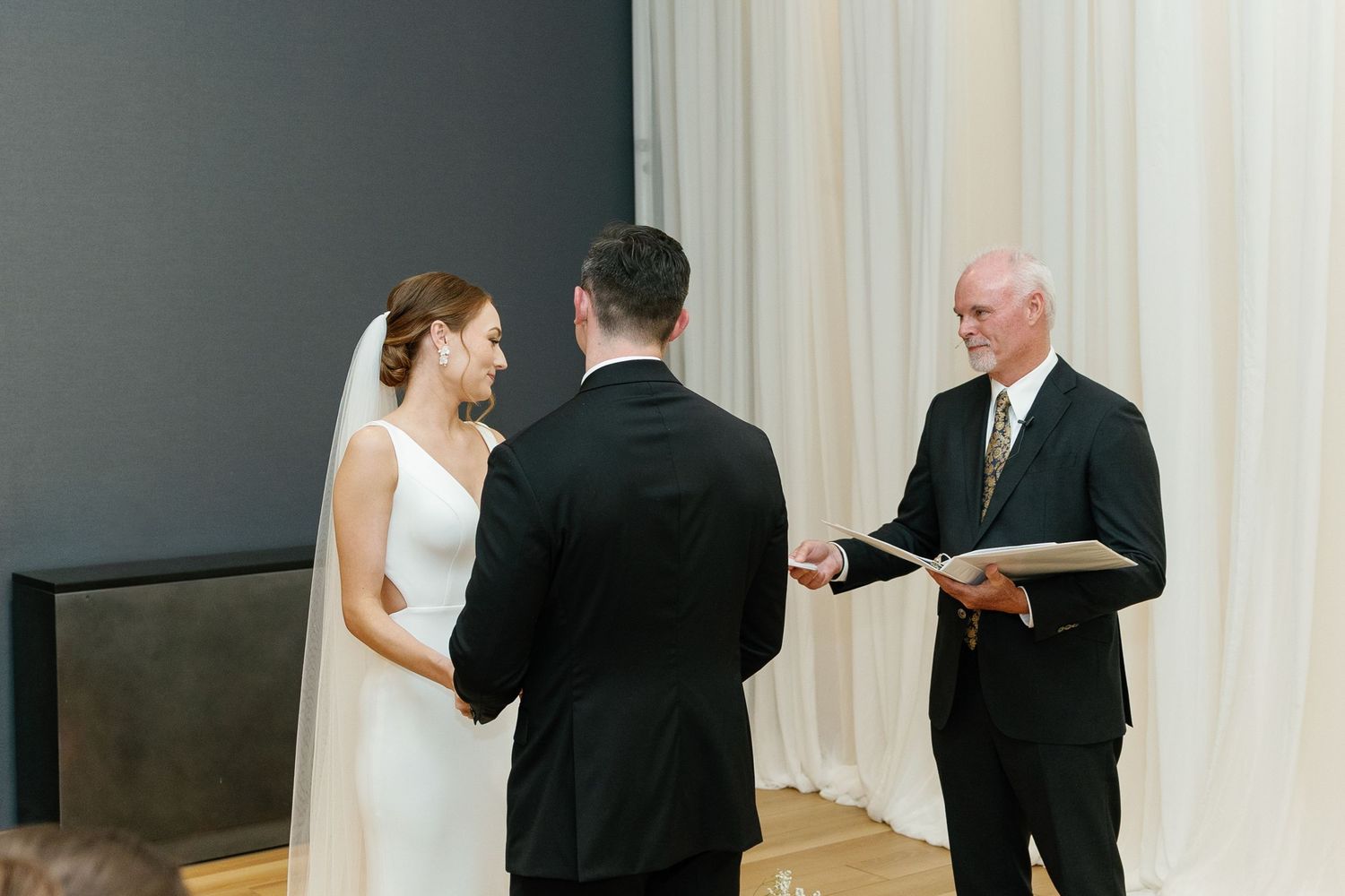 A wedding ceremony montage showing multiple angles of a couple exchanging vows at an indoor venue.