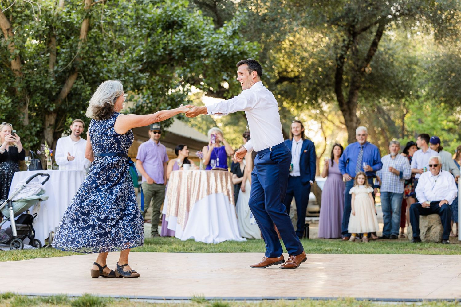 A sequence of candid outdoor wedding moments showing dancing and celebration under trees at a garden reception.