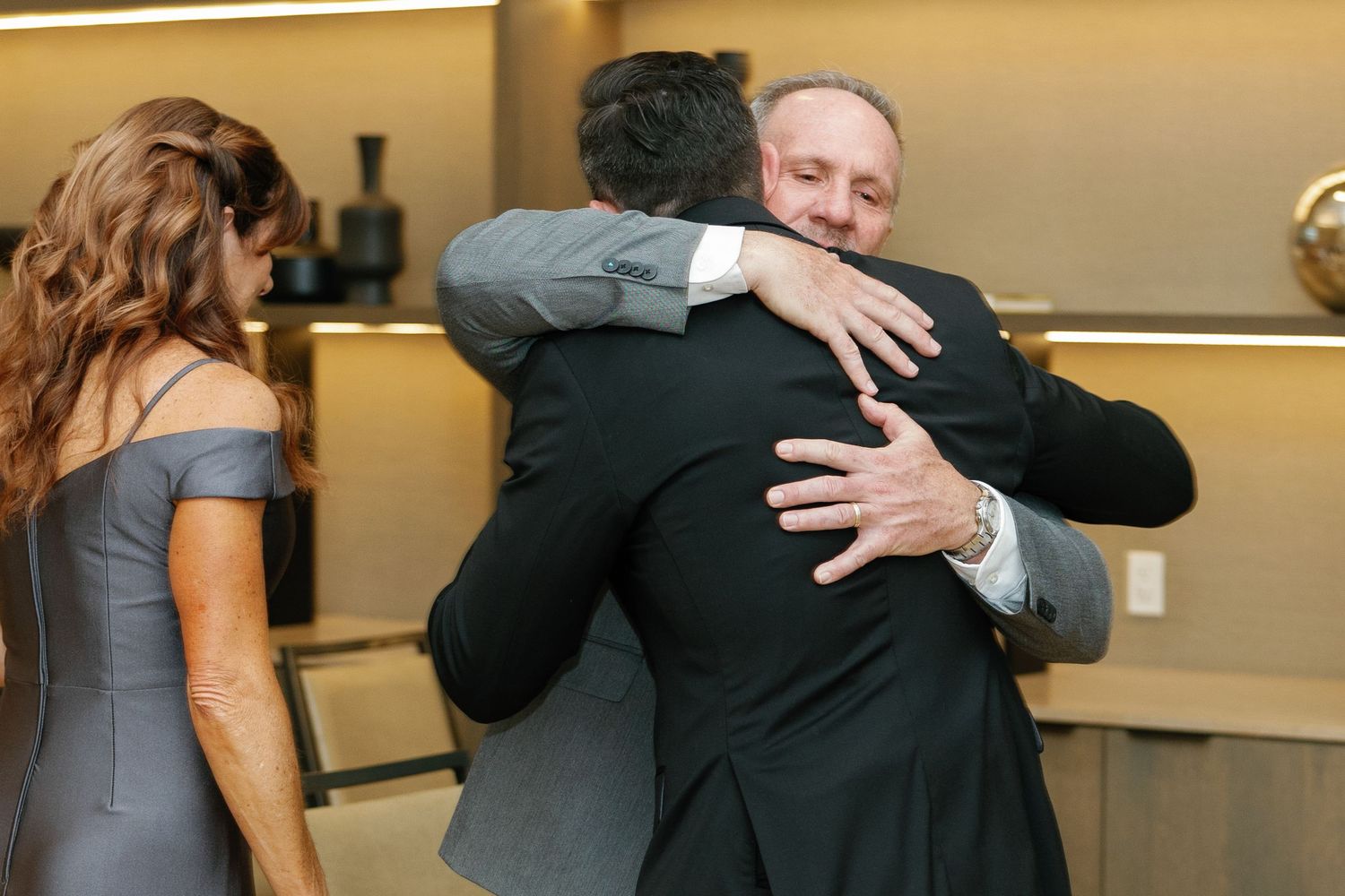 A couple performs an elegant dance move during a wedding reception in a warmly lit ballroom.