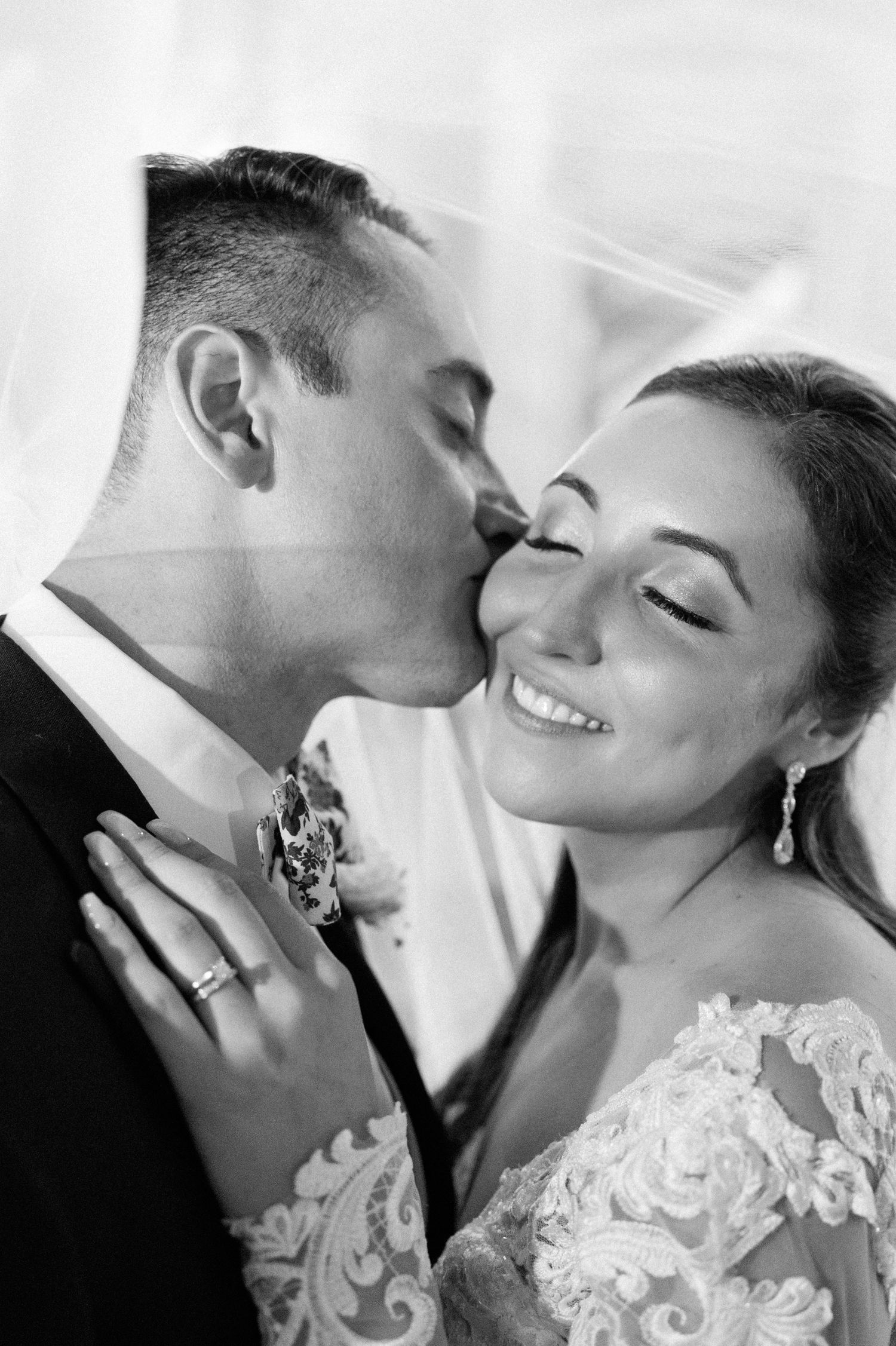 An intimate black and white wedding portrait capturing a tender moment between newlyweds.
